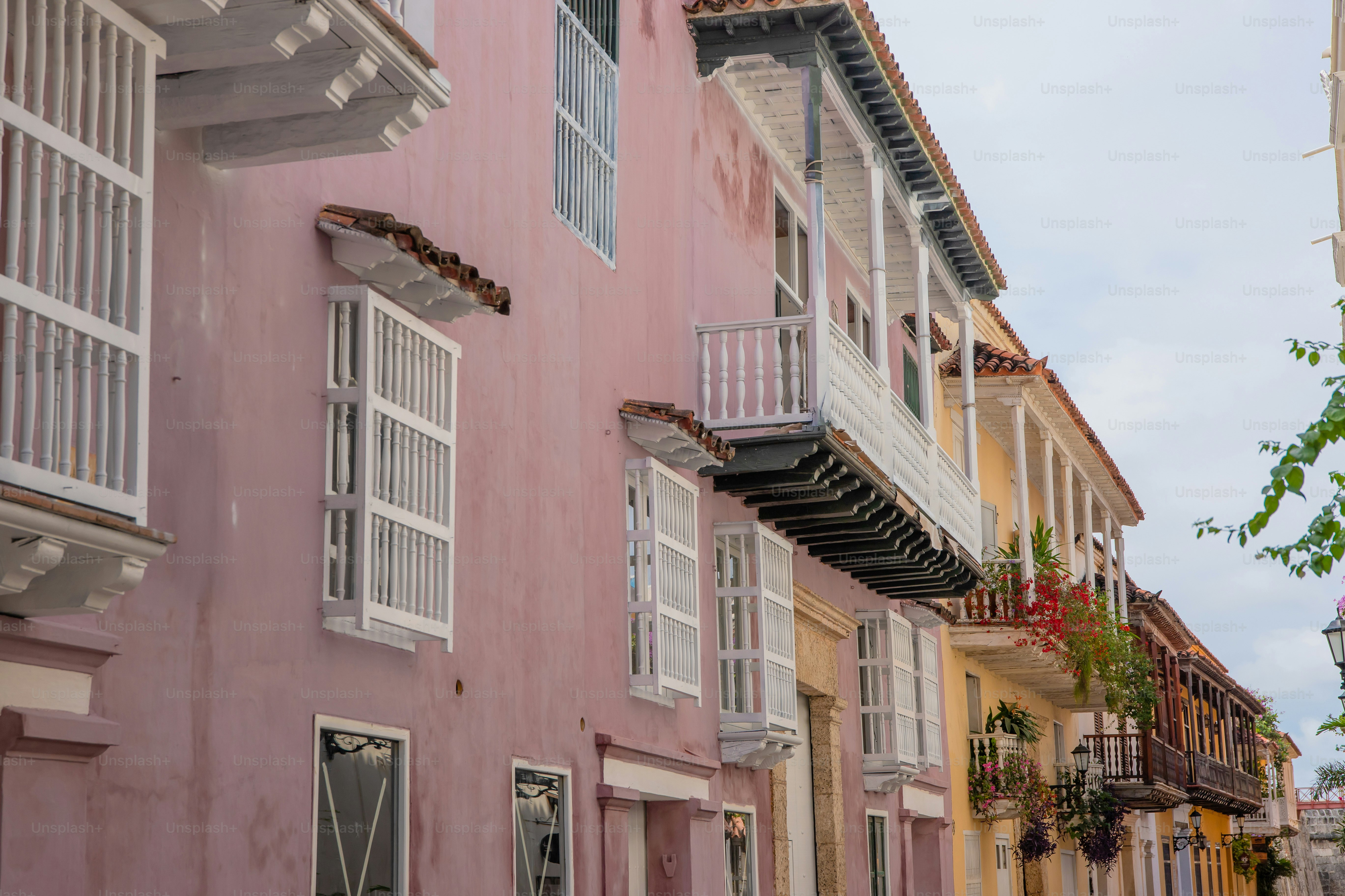 A row of pink buildings with white shutters
