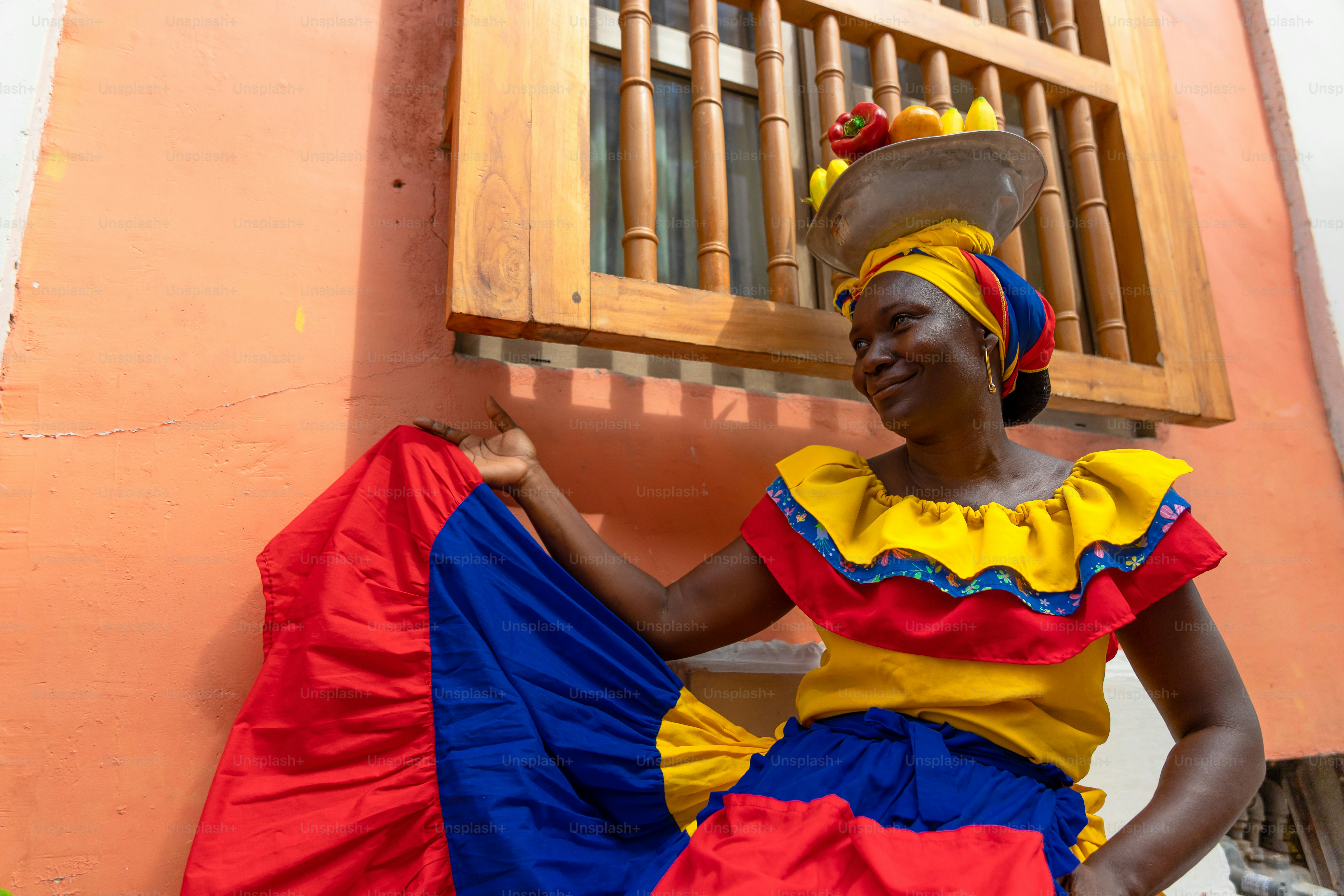 Uma mulher em um vestido colorido sentado em um degrau