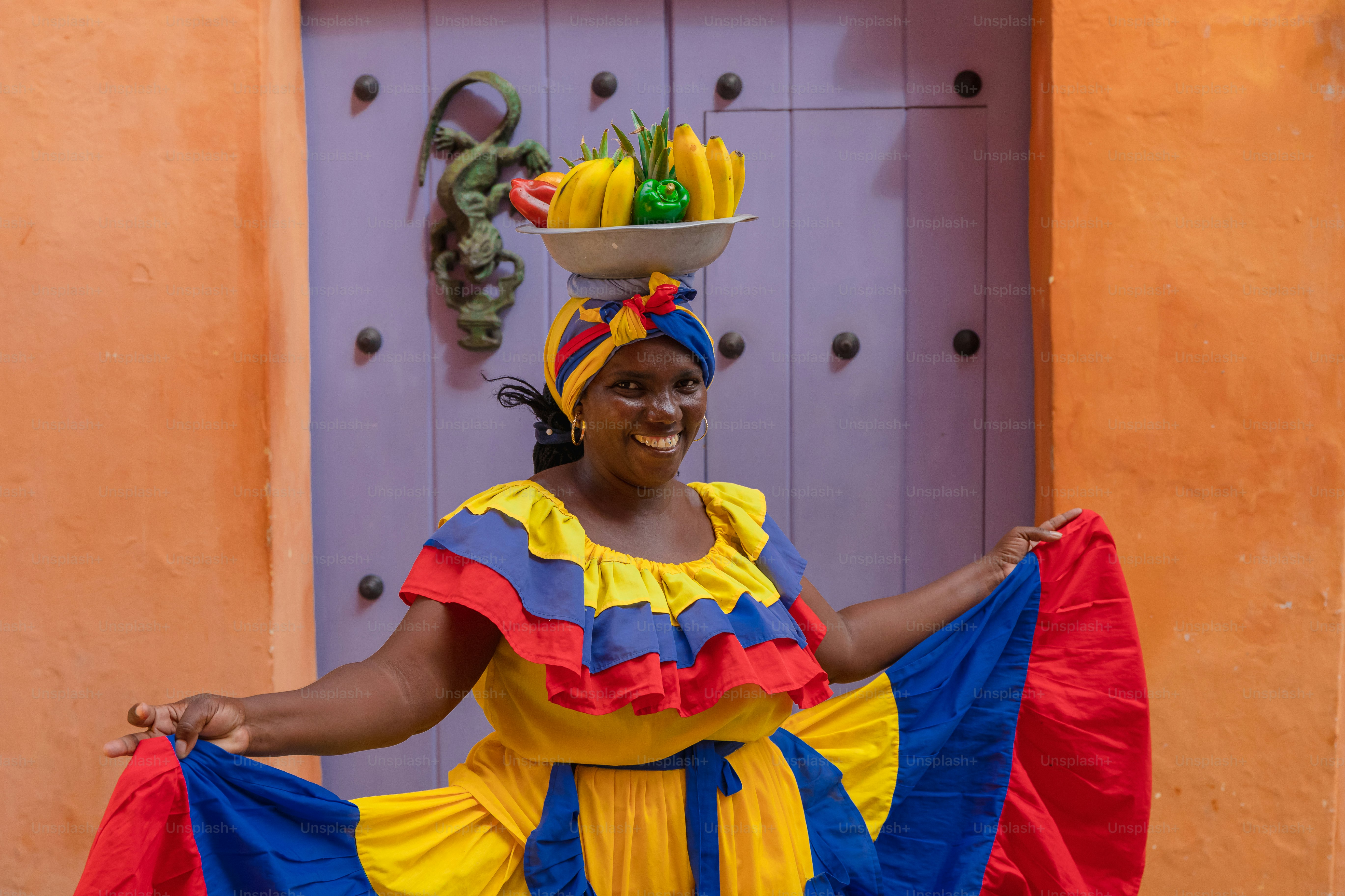 A woman in a colorful dress holding a basket of bananas