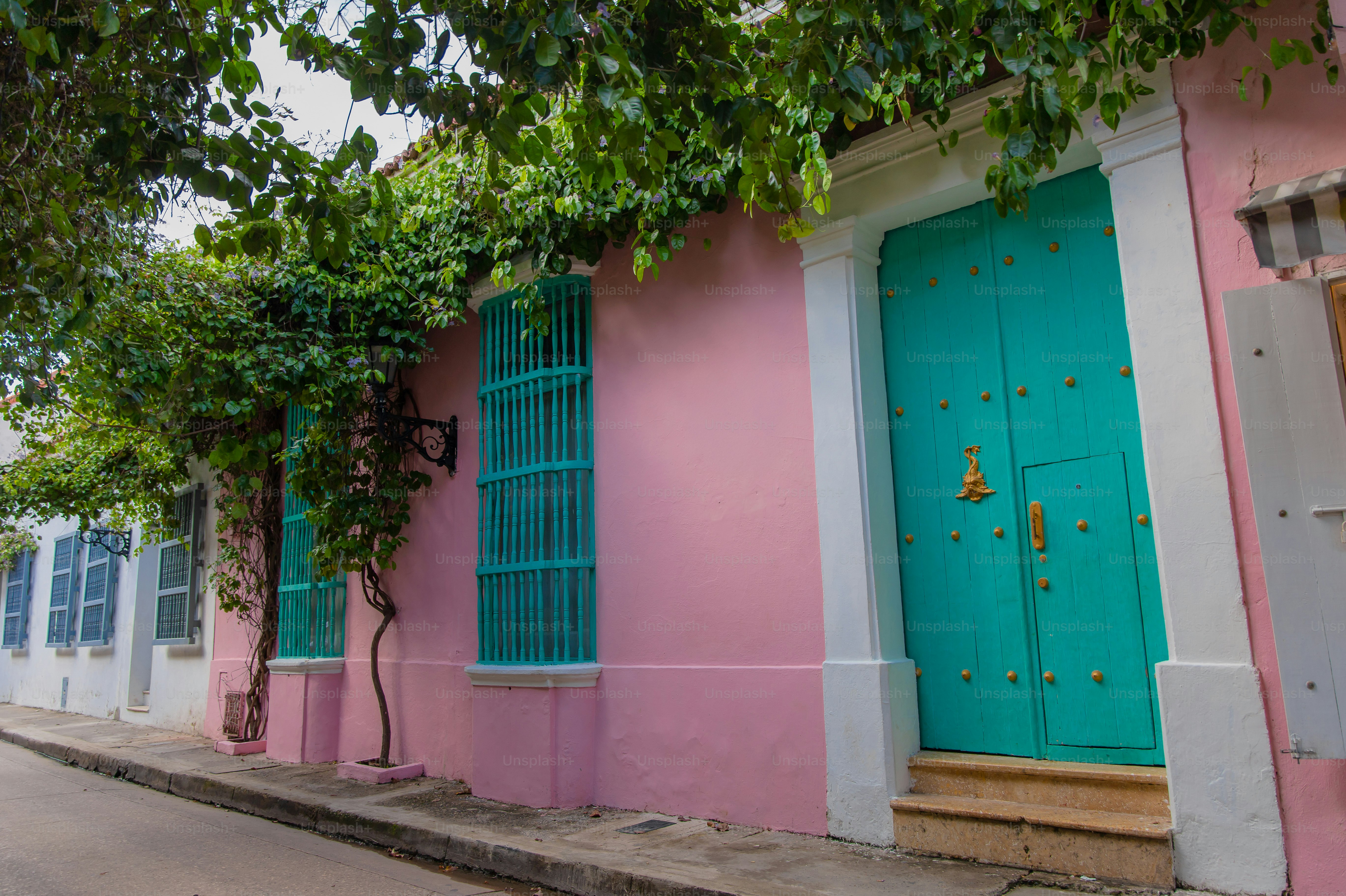 Um edifício rosa e azul com uma porta verde