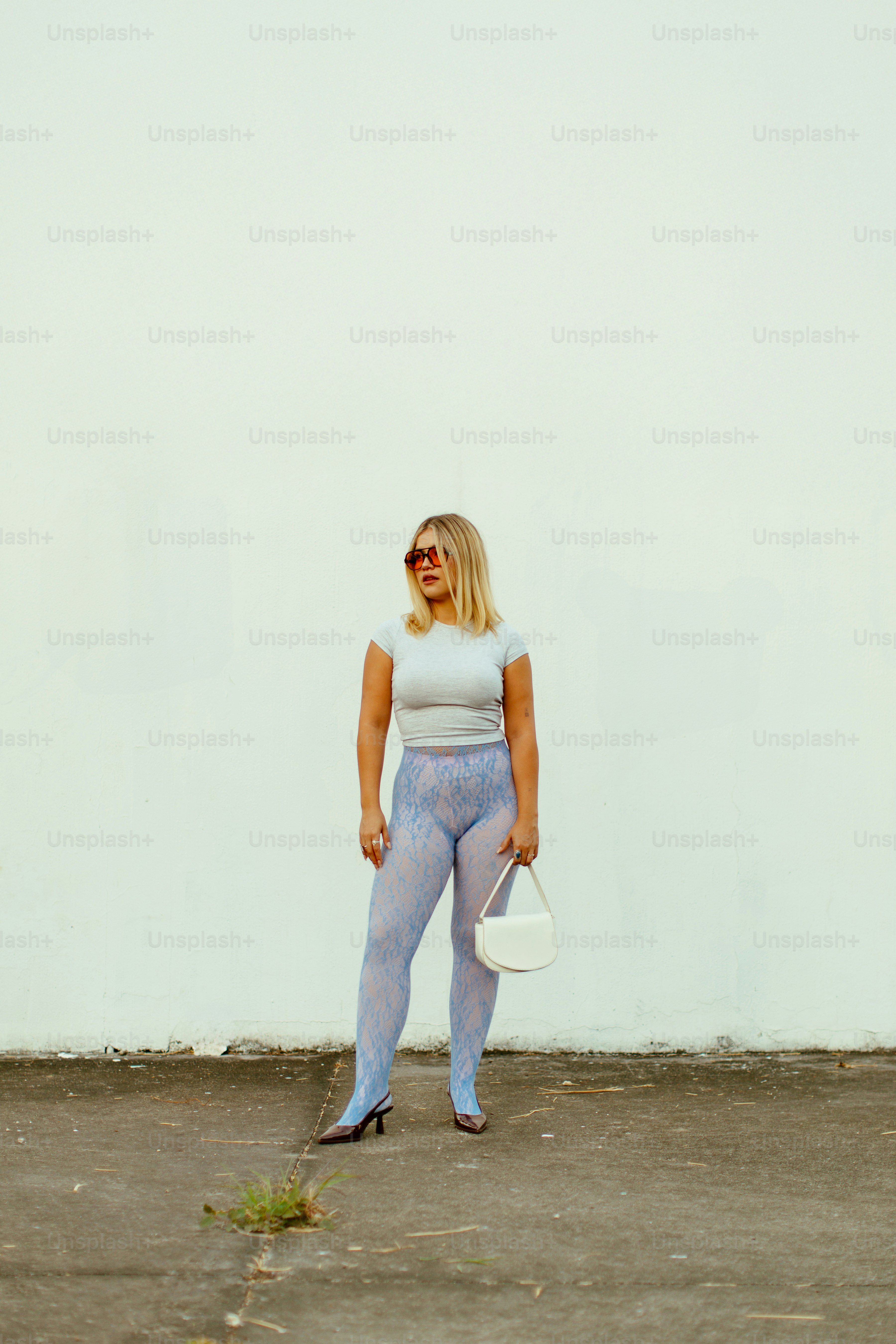 A woman standing in front of a white wall