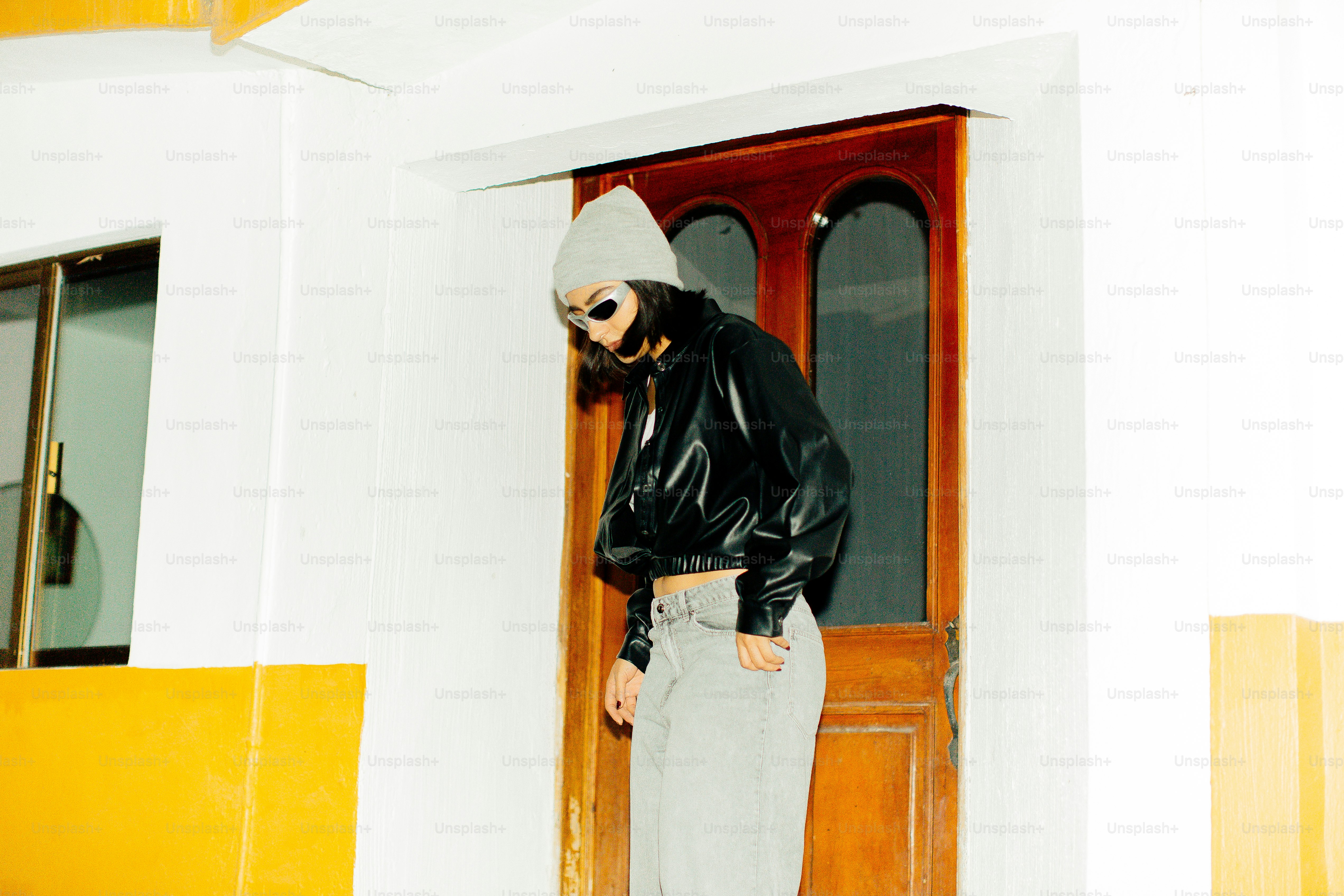 A man standing in front of a door wearing a black jacket photo ...