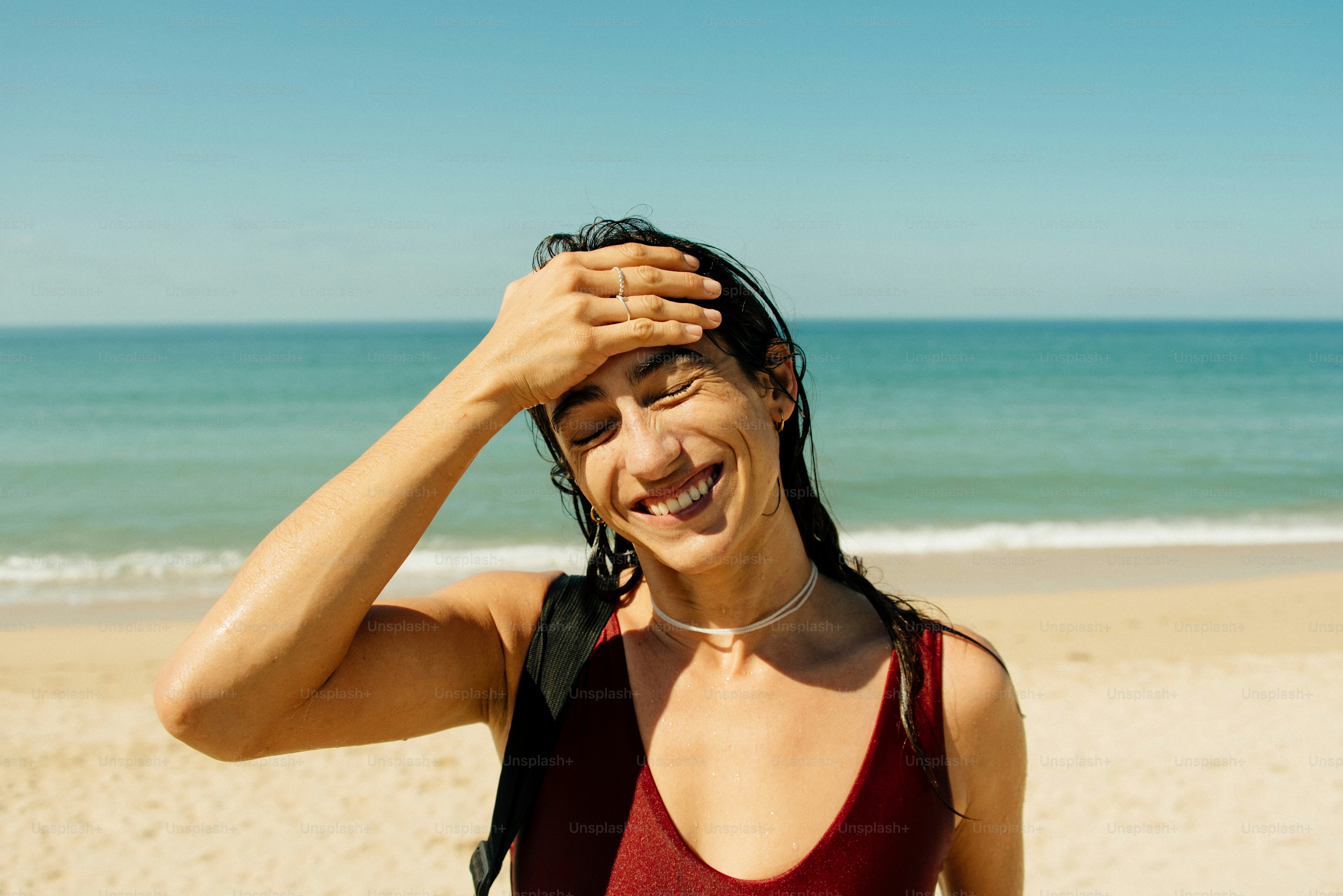Uma mulher em pé no topo de uma praia arenosa