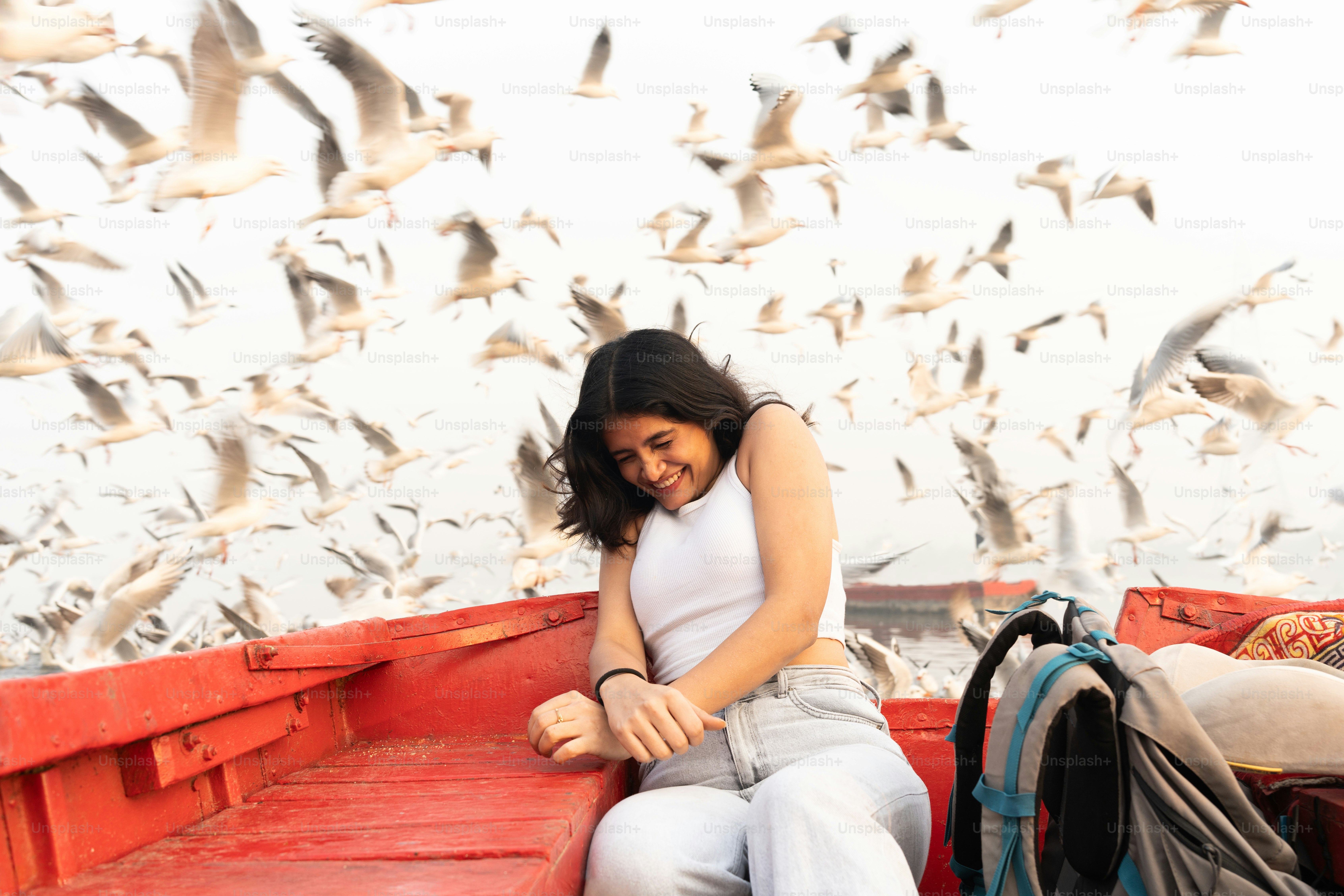 A woman sitting on the back of a red boat