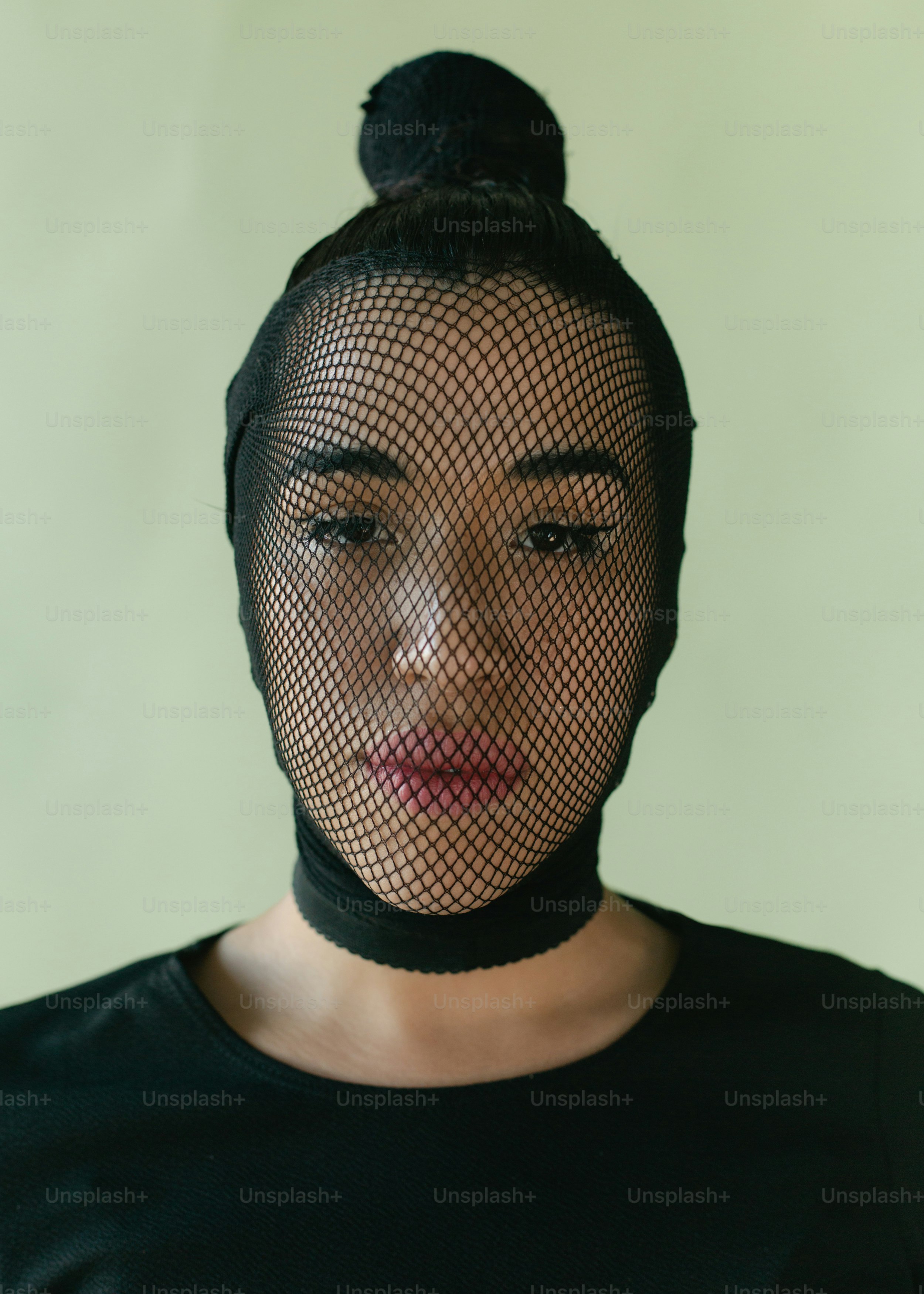 Una mujer con camisa negra y un pájaro en la cabeza