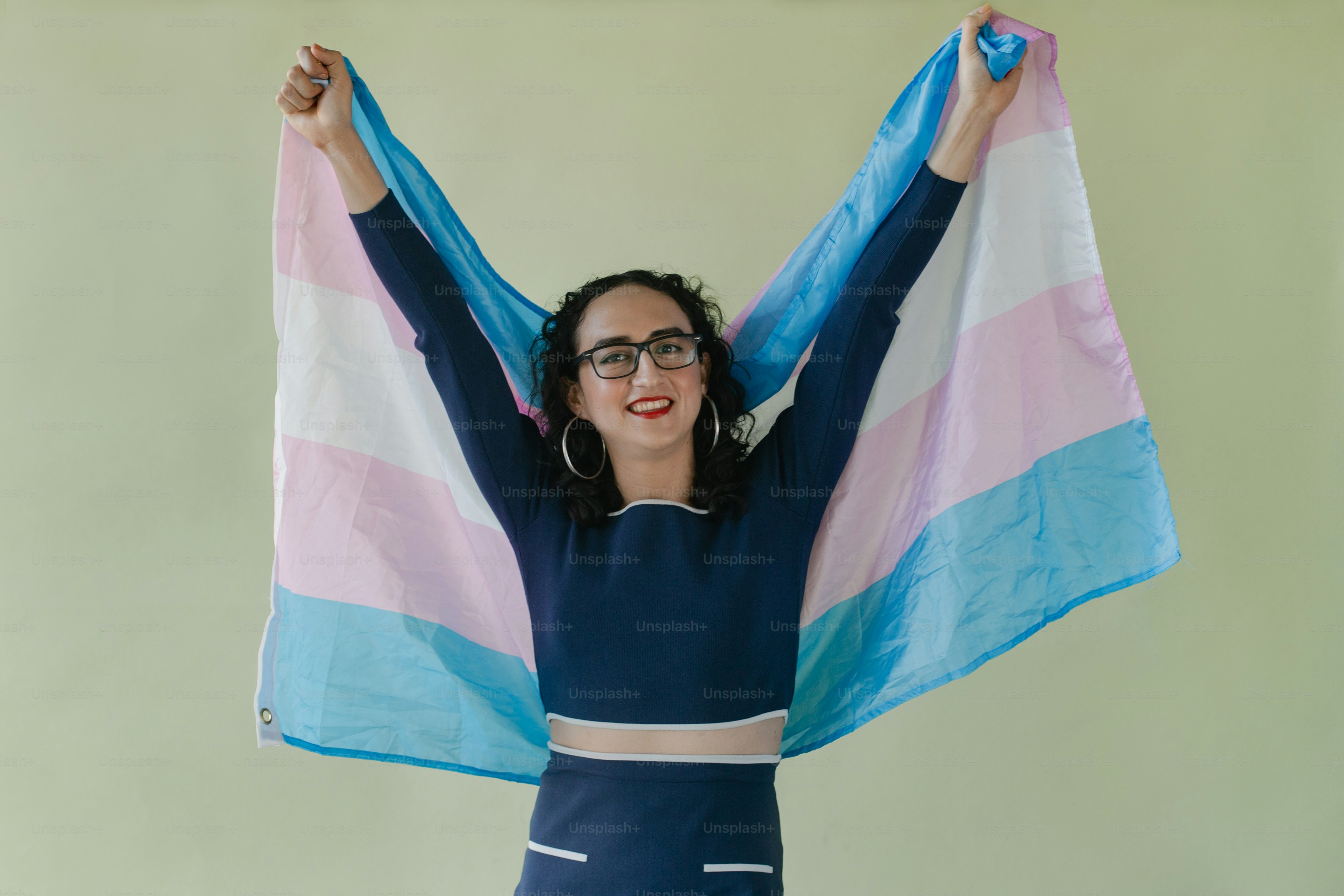 A woman in a blue dress holding a blue and pink towel