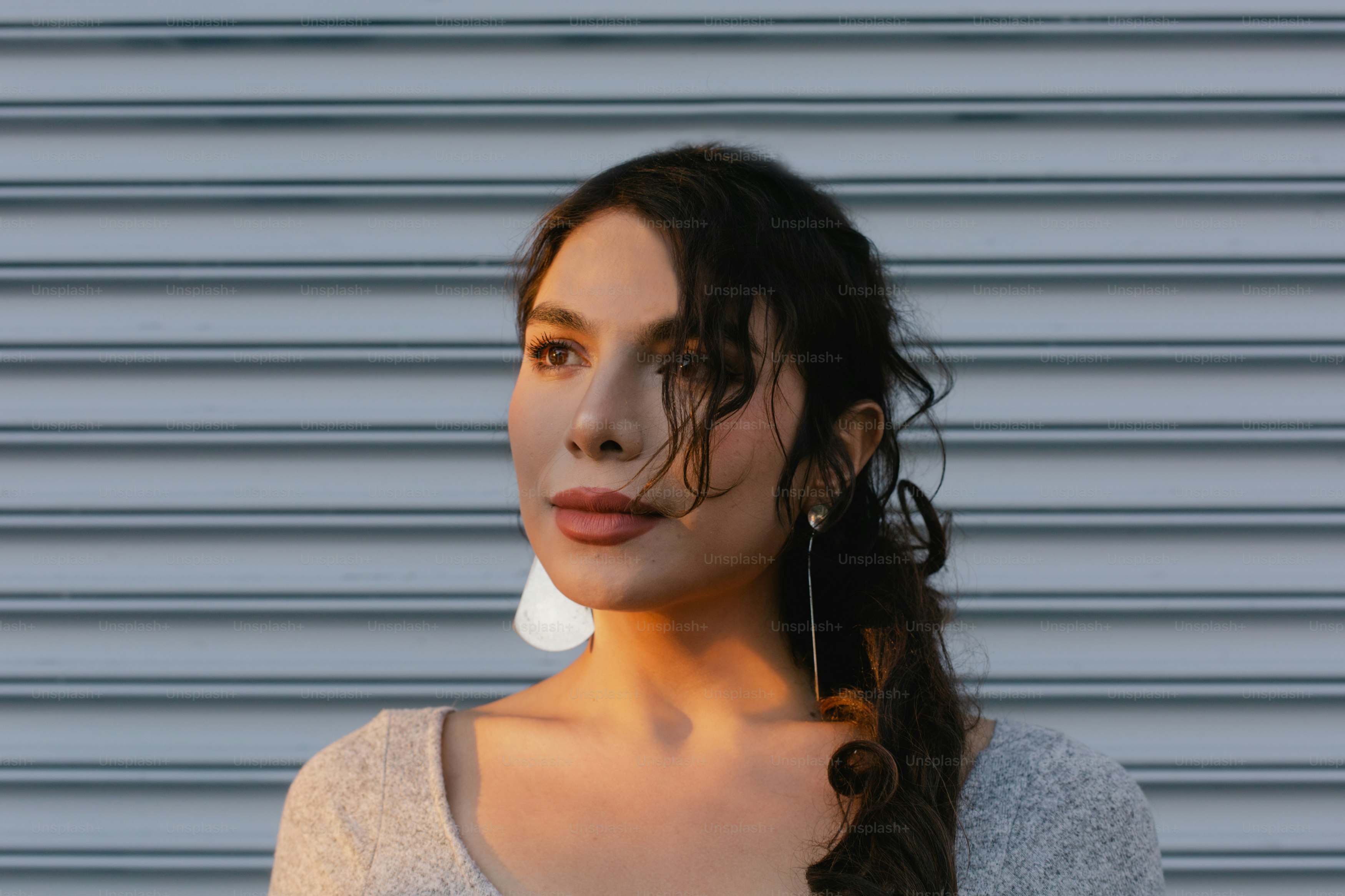 A woman wearing a white shirt and a pair of earrings