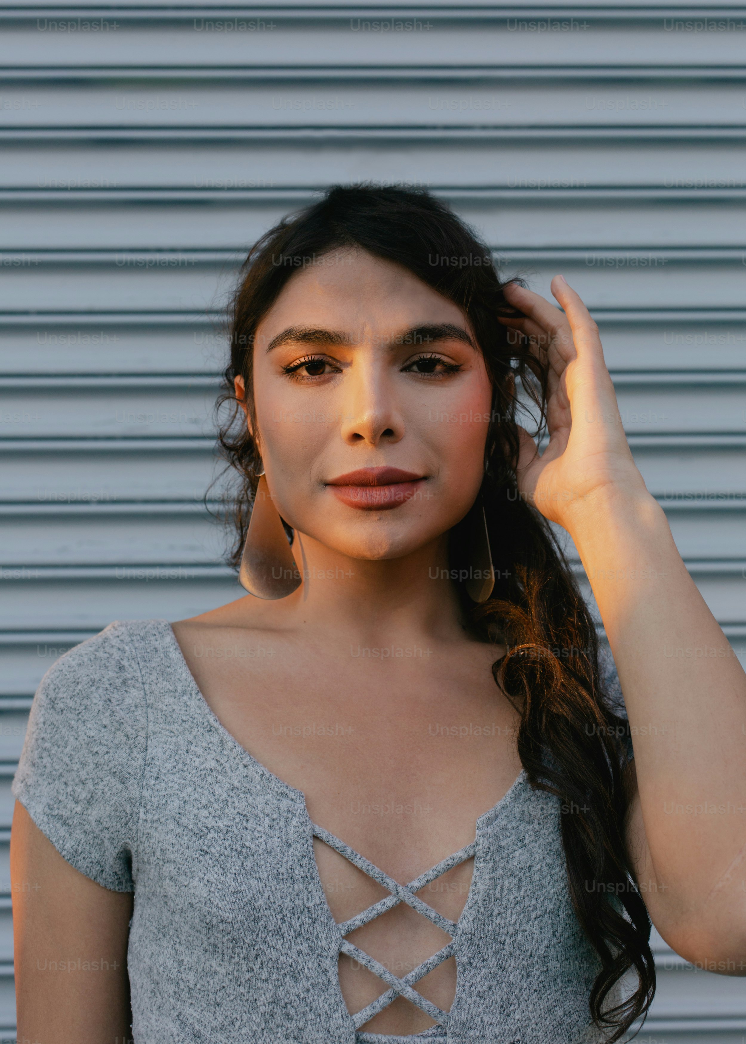 A woman with long hair wearing a gray top