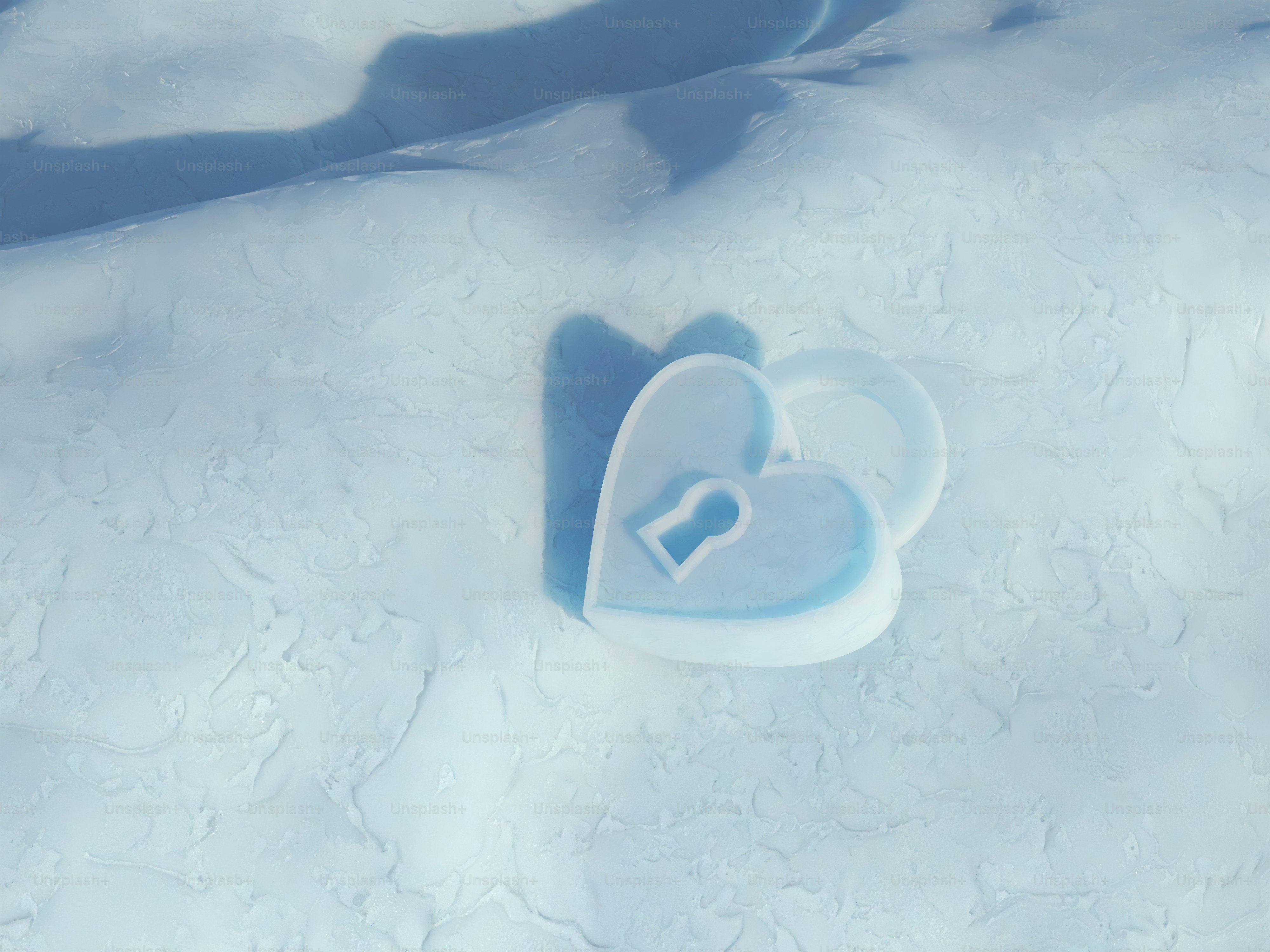 A heart shaped ice block sitting on top of a snow covered ground
