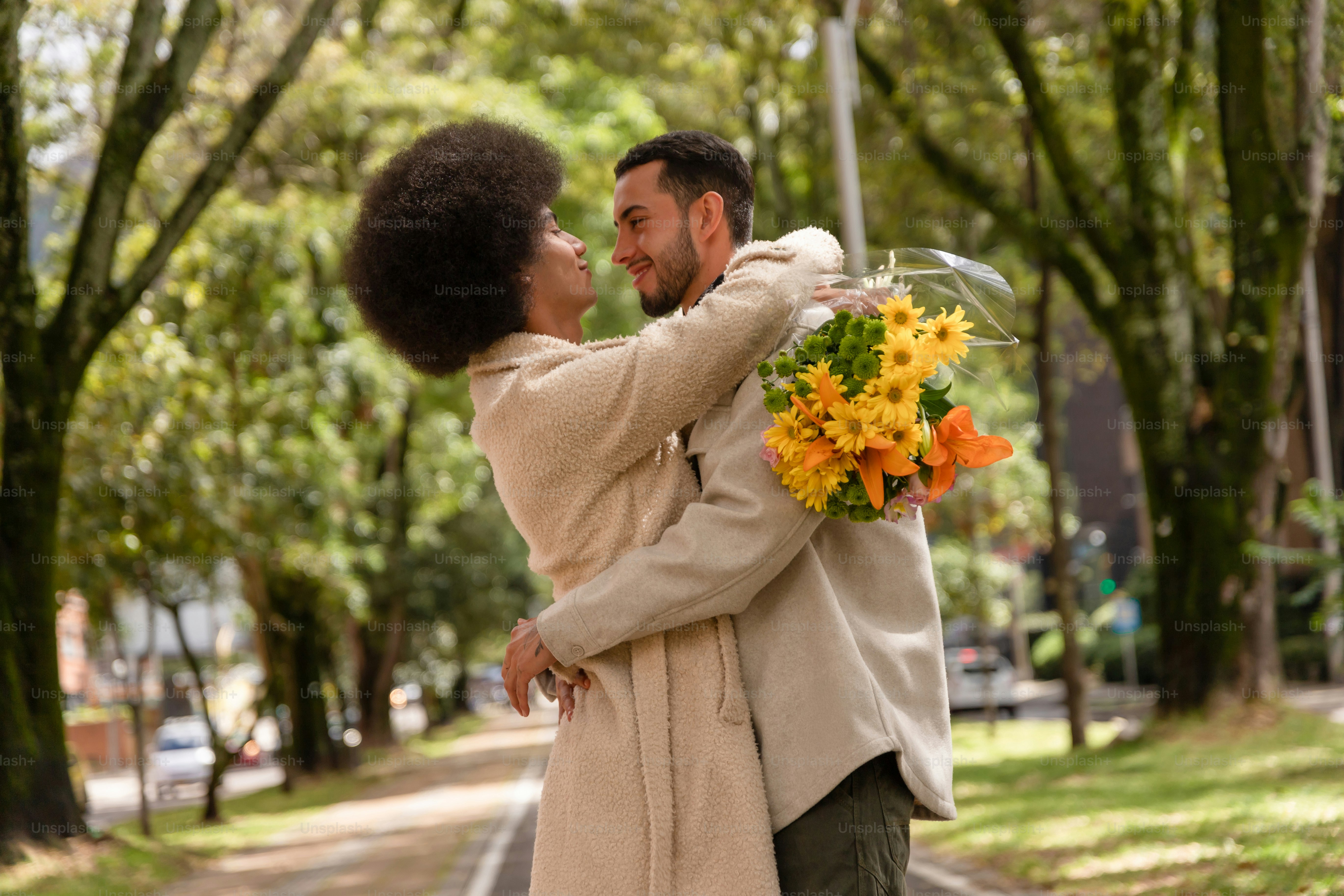 A man and a woman hugging each other in the park