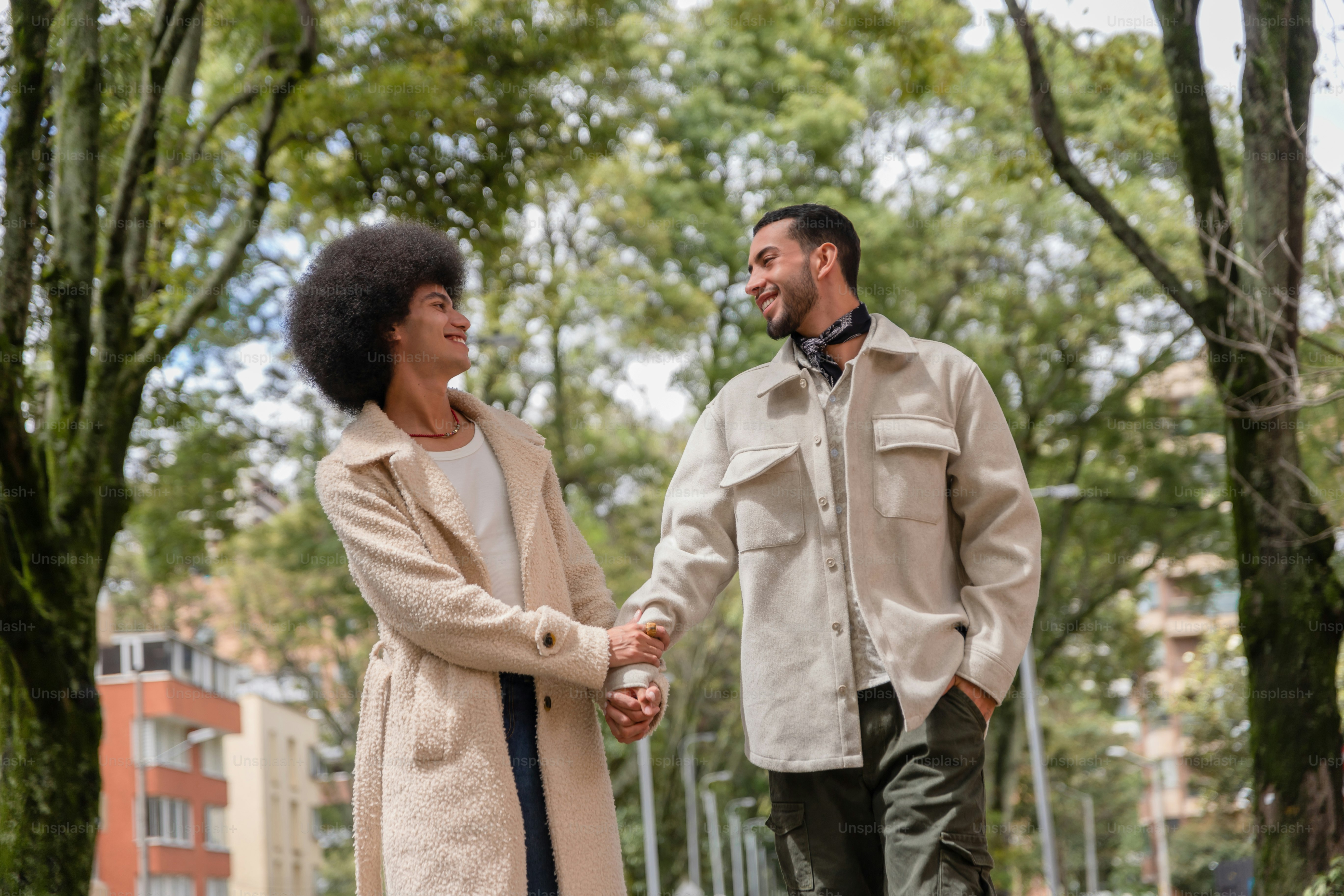 A man and a woman standing in a park holding hands