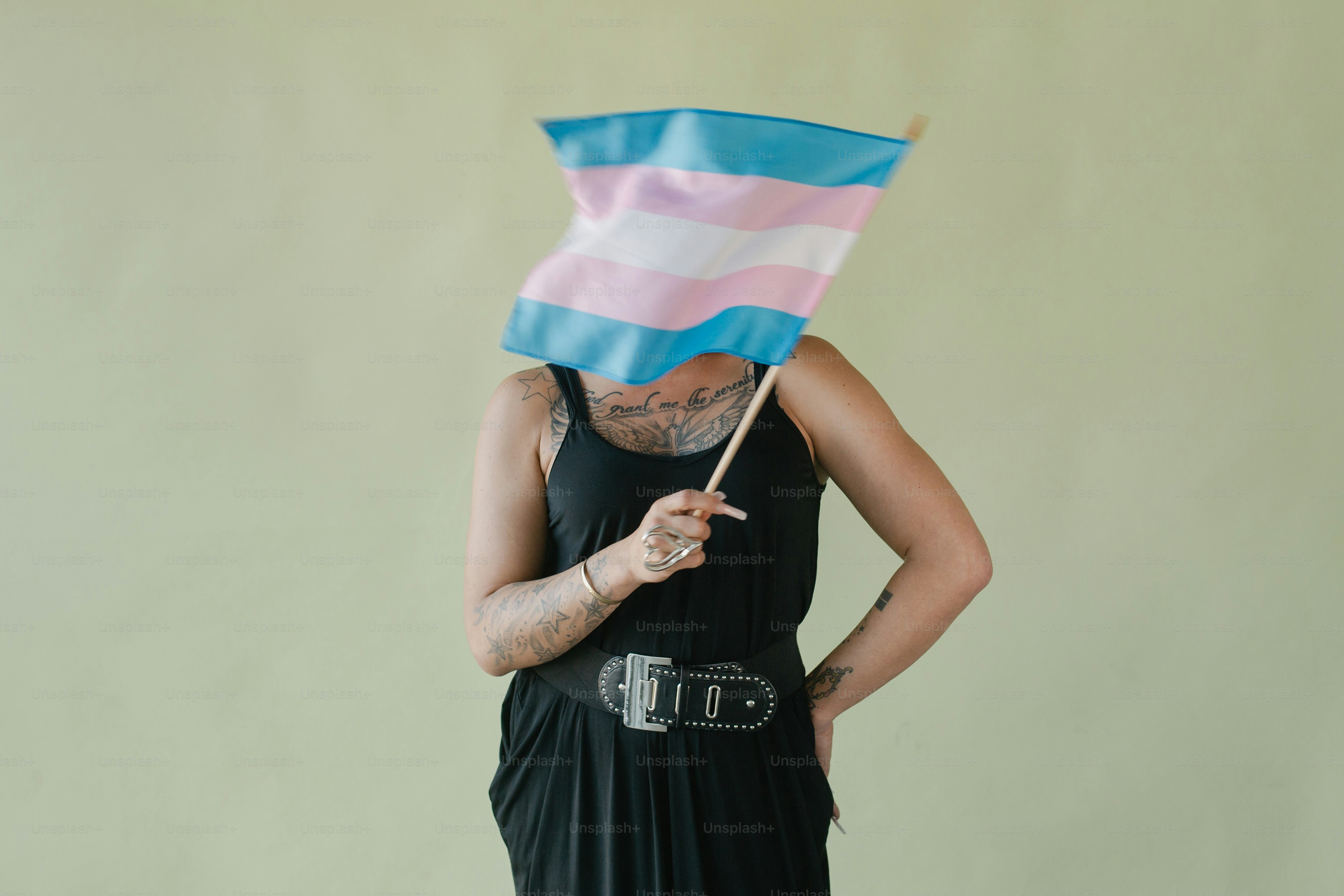 A woman in a black dress holding a blue and pink flag
