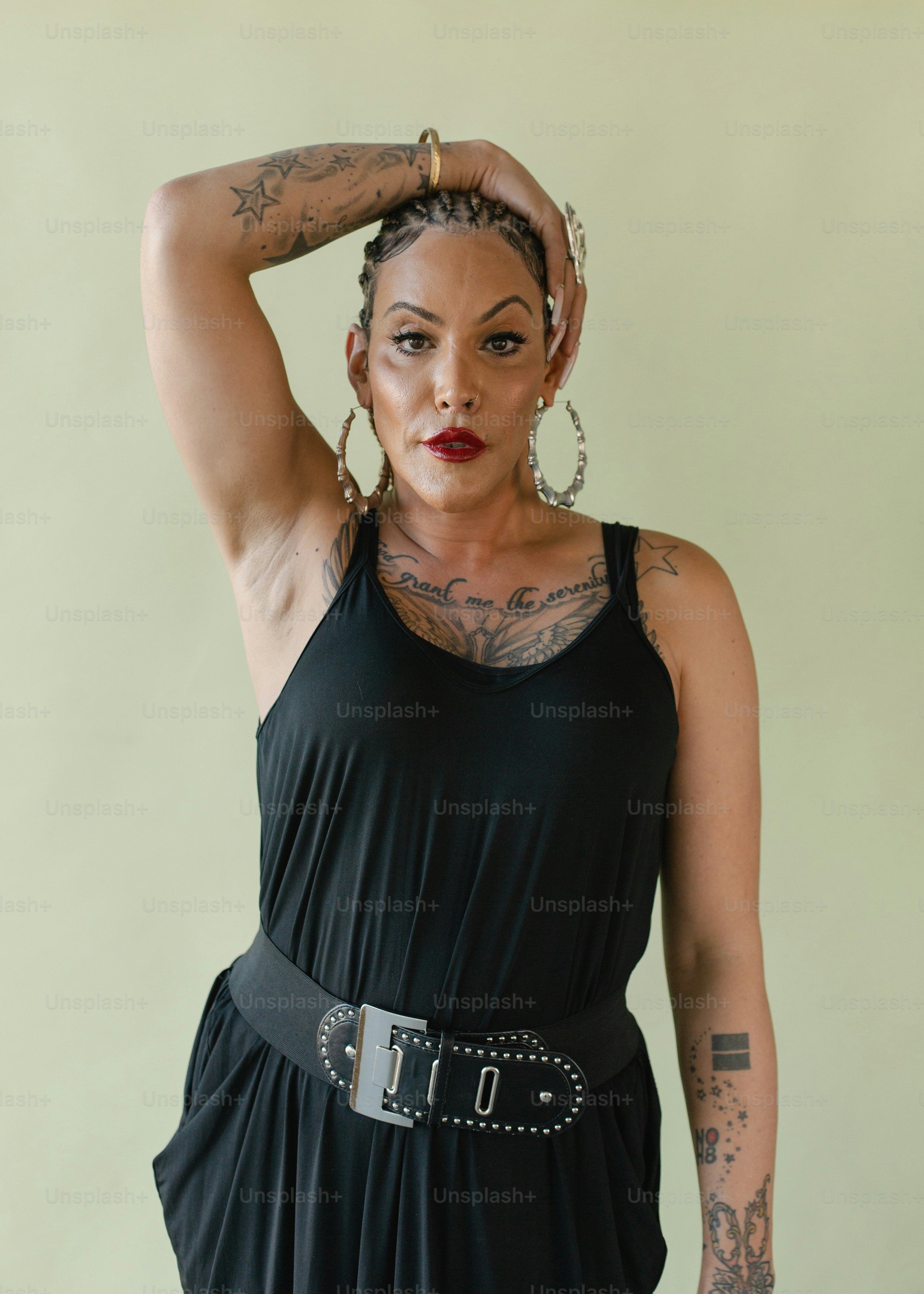 A woman in a black dress with a tattoo on her arm