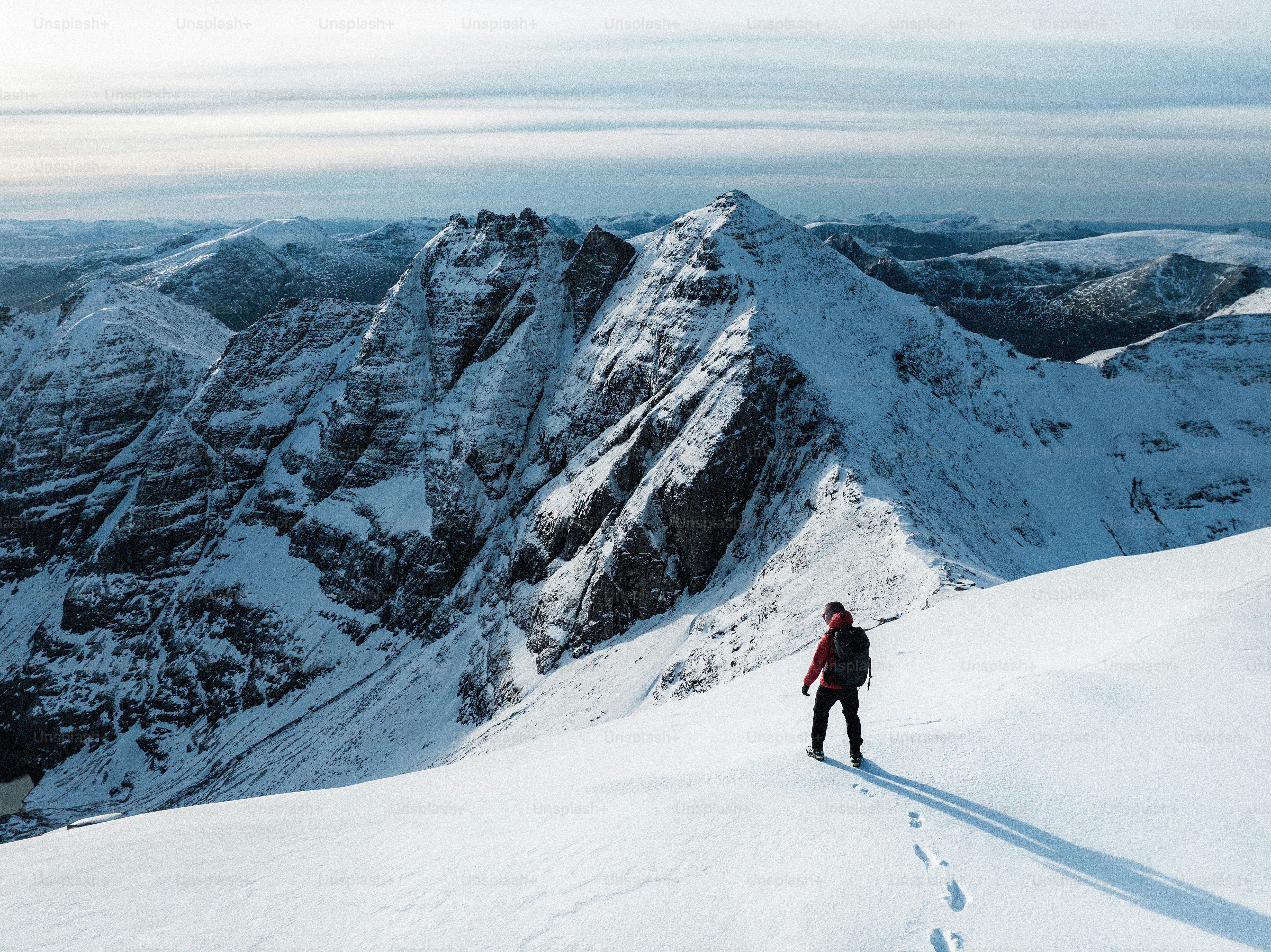 A man standing on top of a snow covered mountain