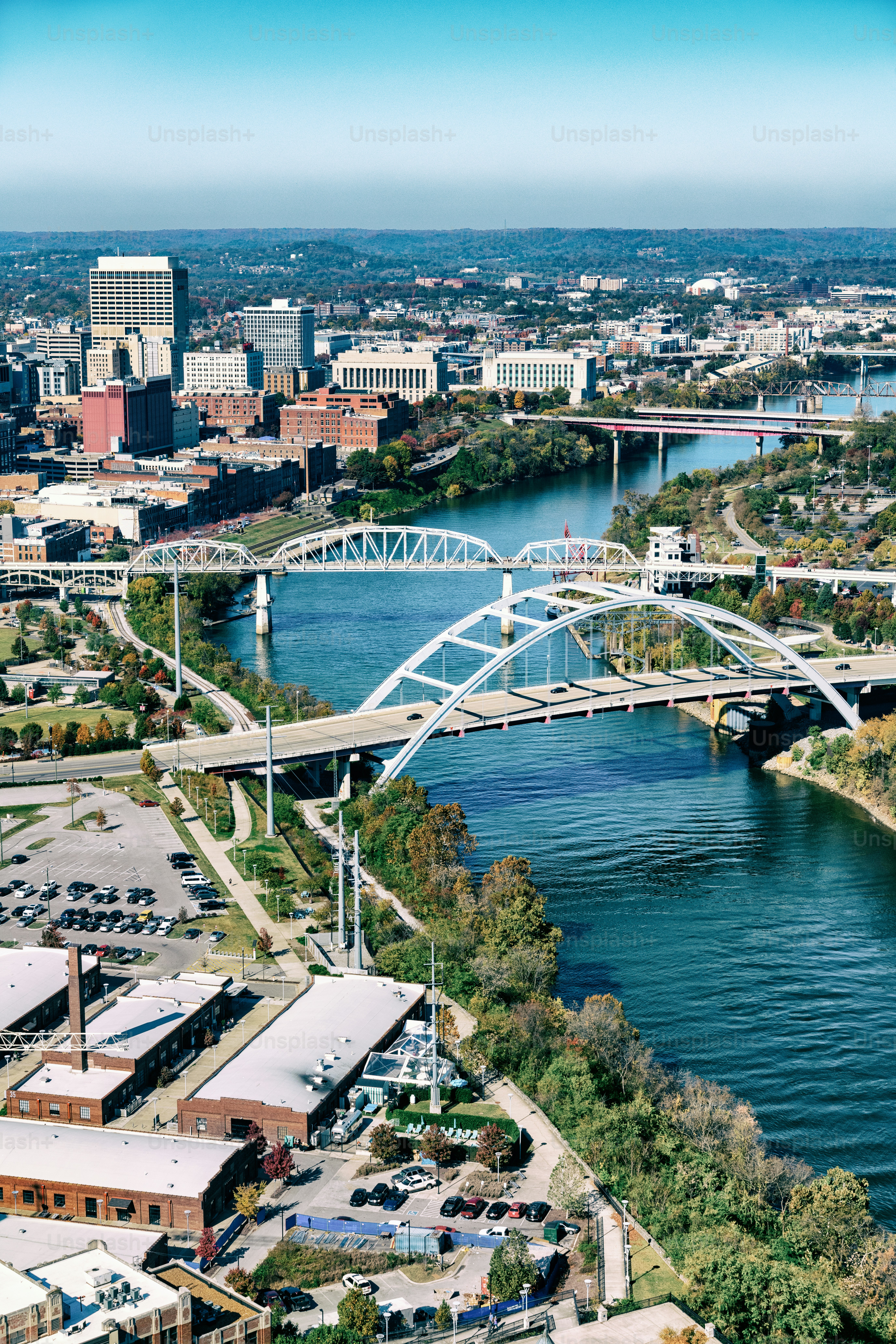 The Cumberland River running through downtown Nashville, Tennessee with several bridges spanning the river shot from an altitude of about 1000 feet.