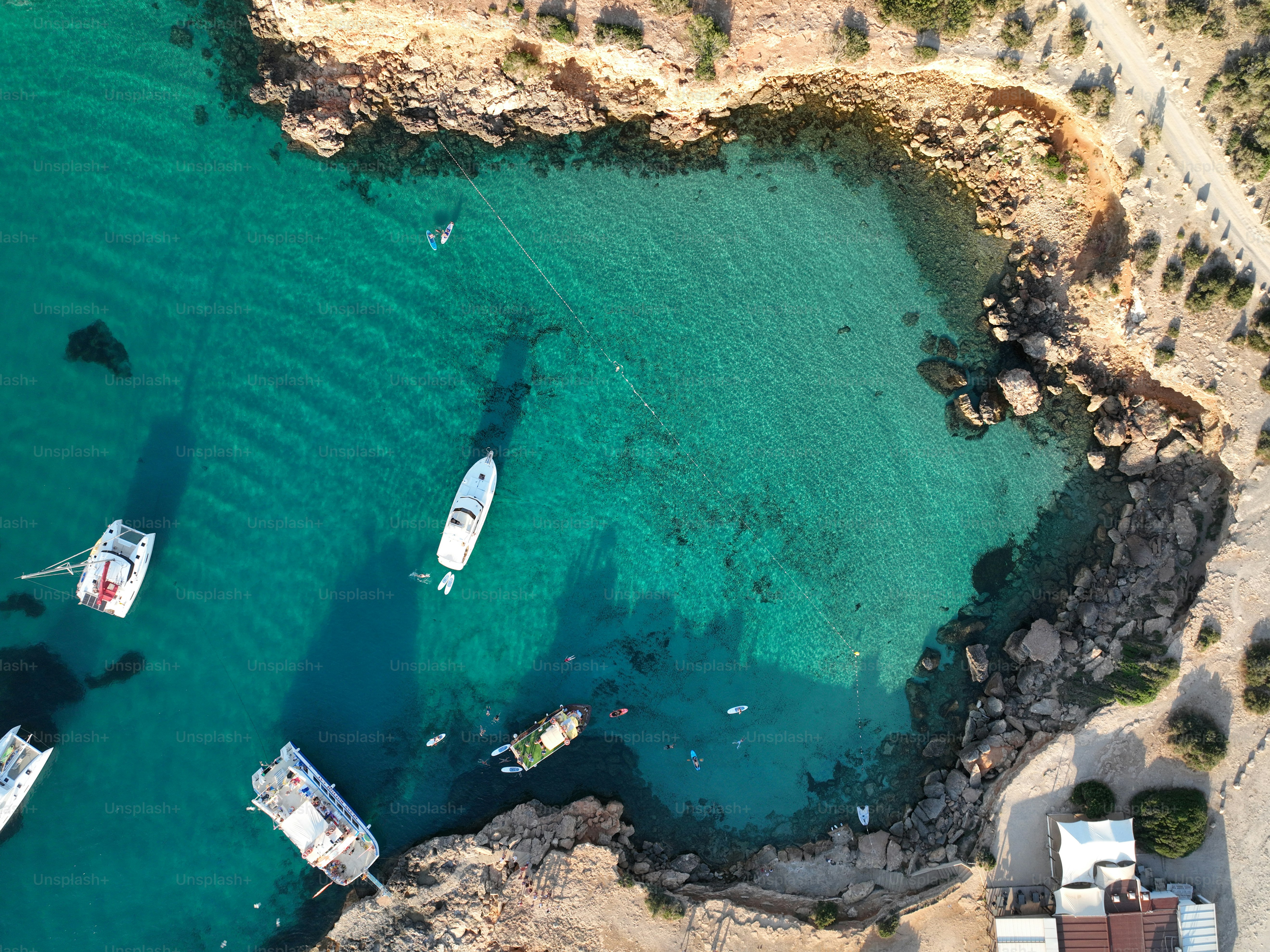 Aerial view of Ibiza beach in summer, Cala Comte beach. Boats and yachts in crystal clear water.