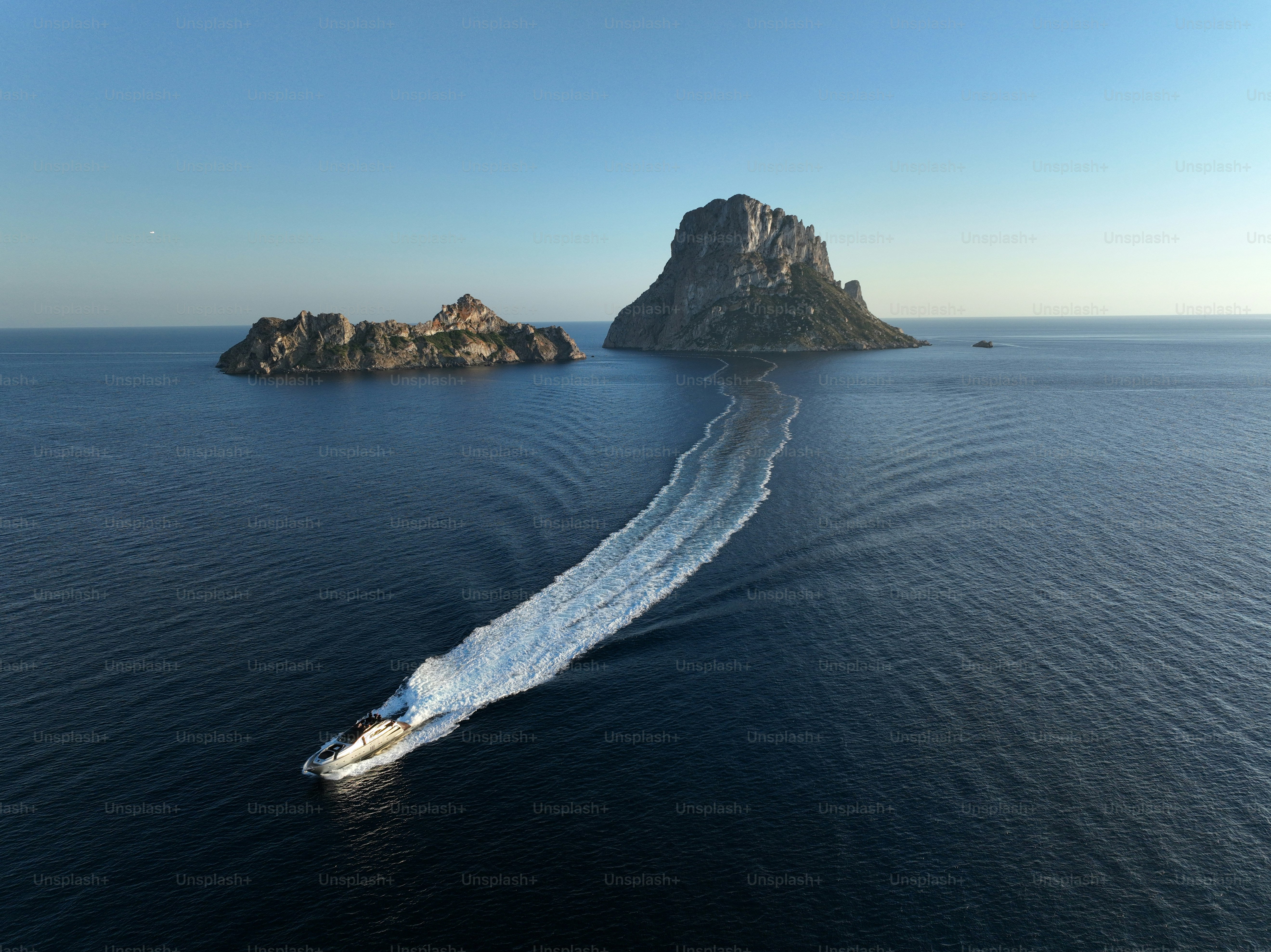 Aerial view of Es Vedra and a yacht sailing the sea. Ibiza.