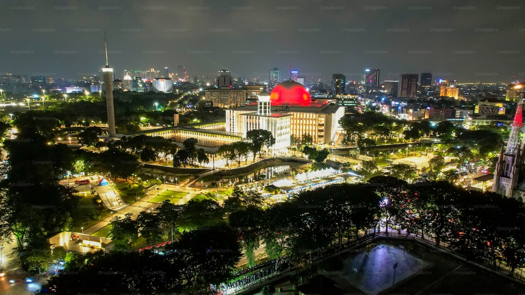 Aerial view of Istiqlal Mosque. It is the largest mosque in Southeast Asia and noise cloud at night with Jakarta citysca