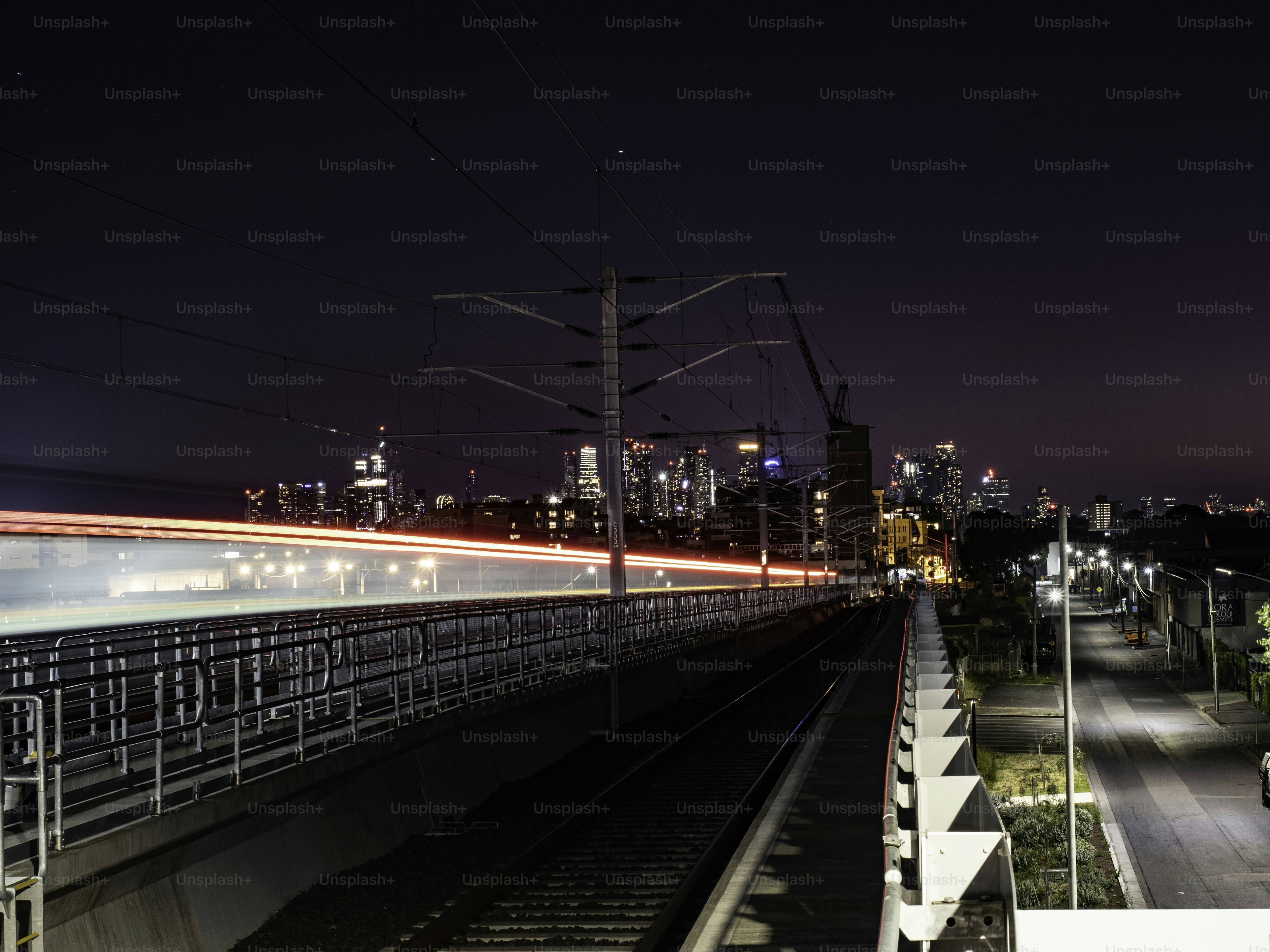 Melbourne skyline at night next to rail tracks