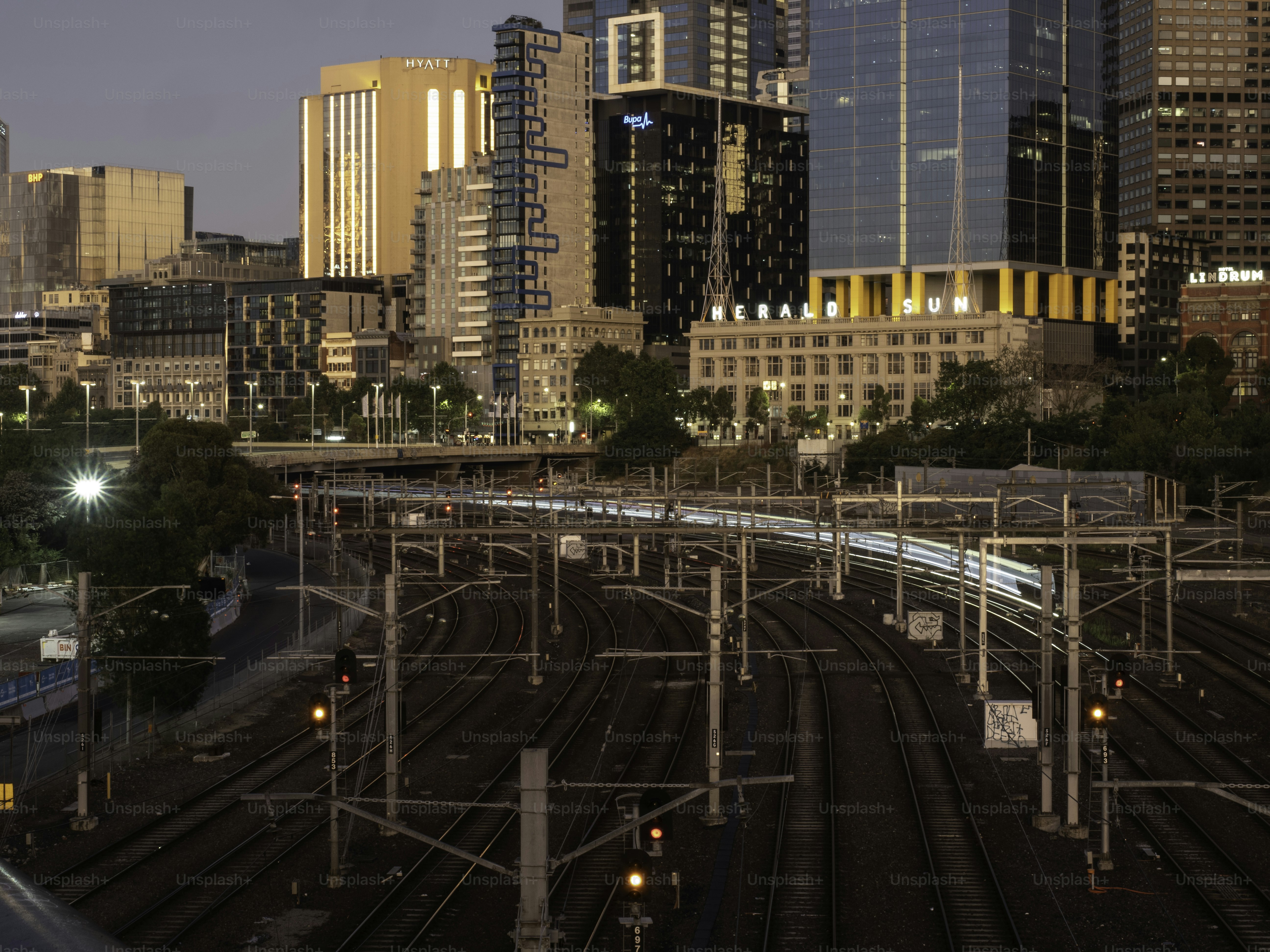 Melbourne skyline at sunrise with the train lines in the foreground