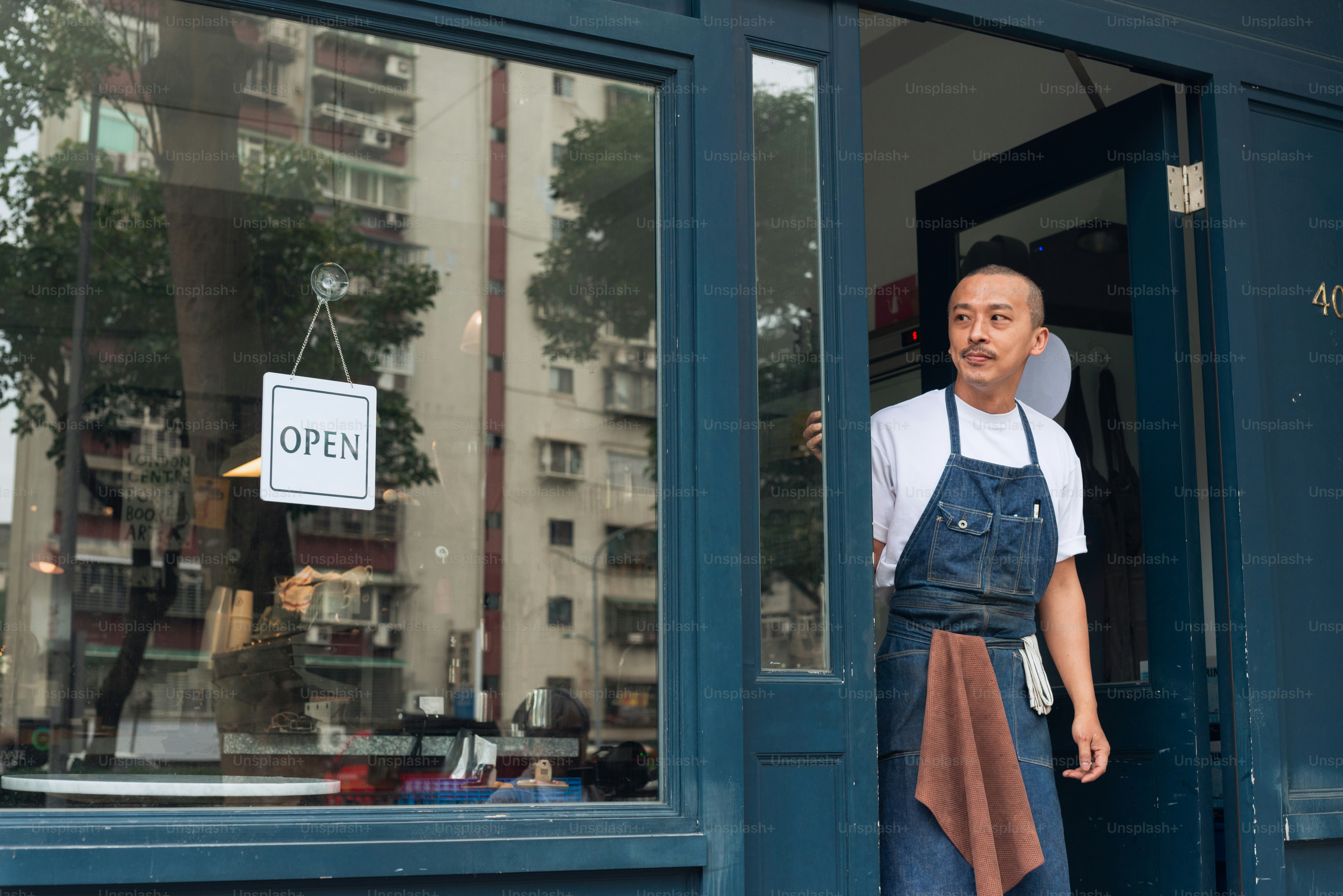 Dueño de una cafetería con letrero de abierto