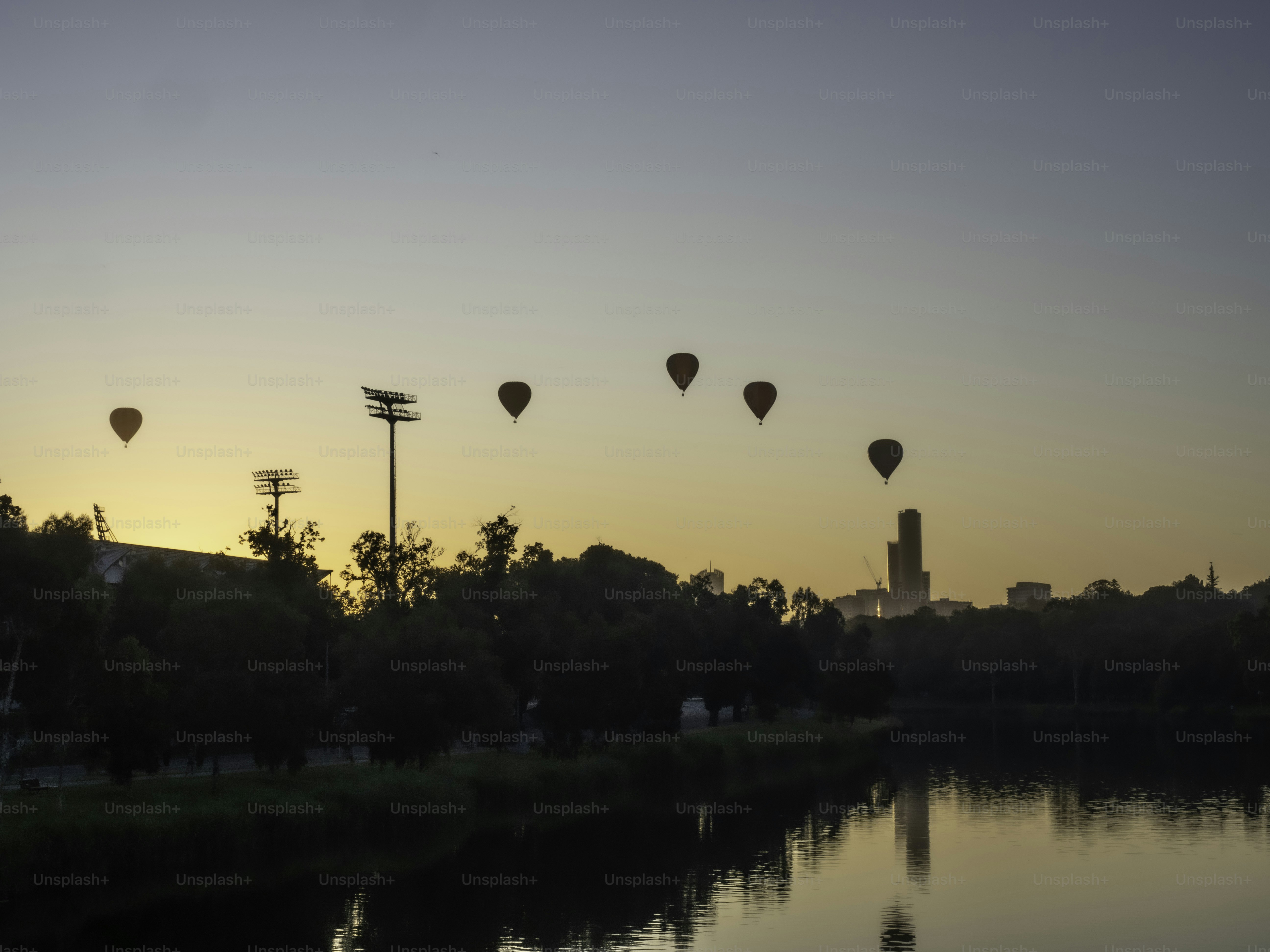 Urban skyline with hot air balloons in silhouette