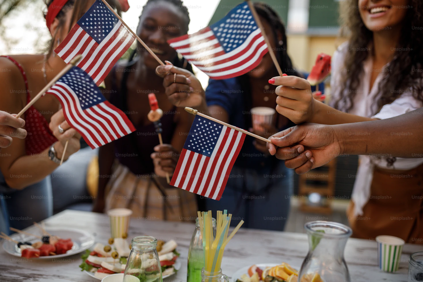 Friends clinking glasses at a stylish 4th of July backyard party