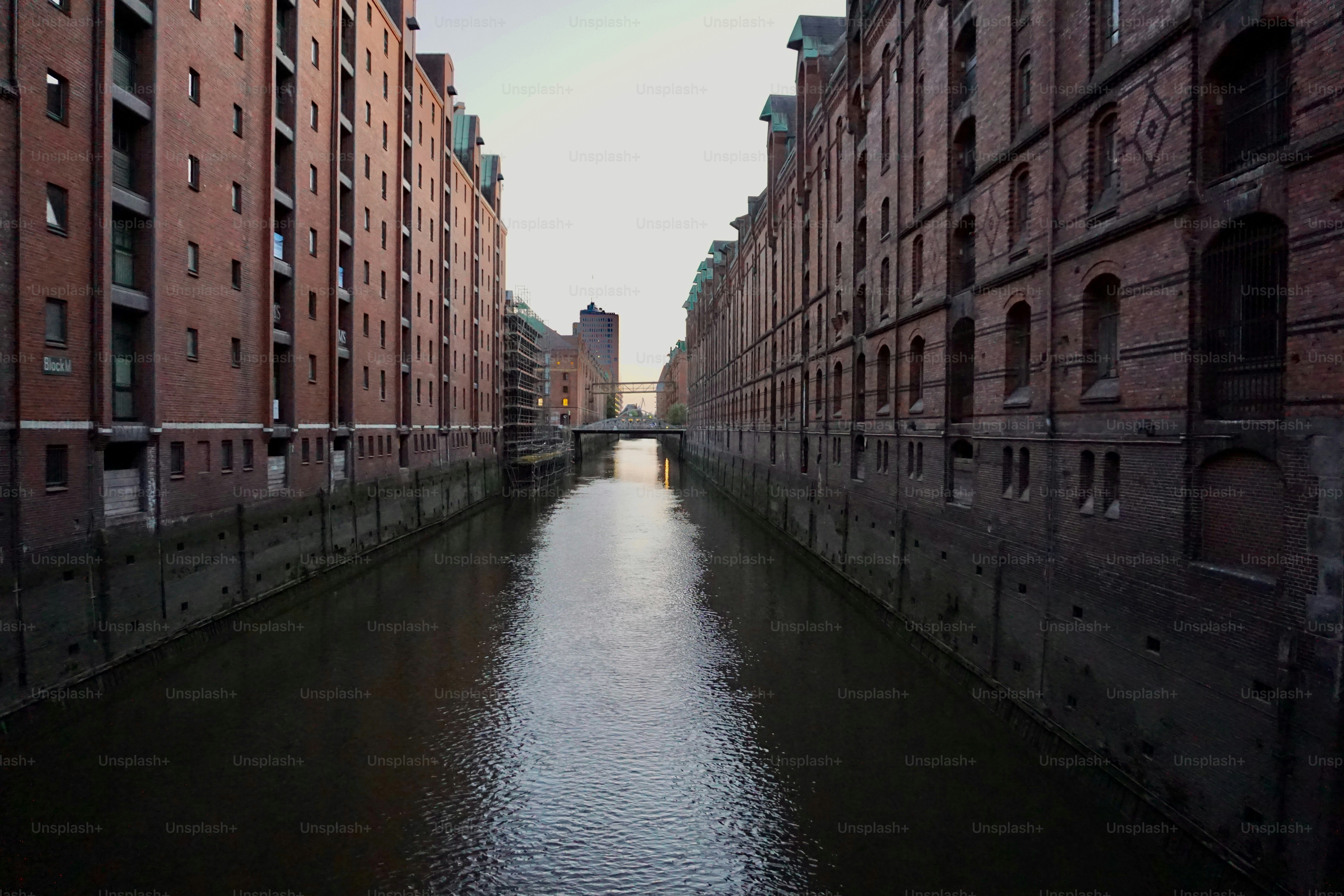 A narrow canal between tall red brick warehouse buildings in Hamburg
