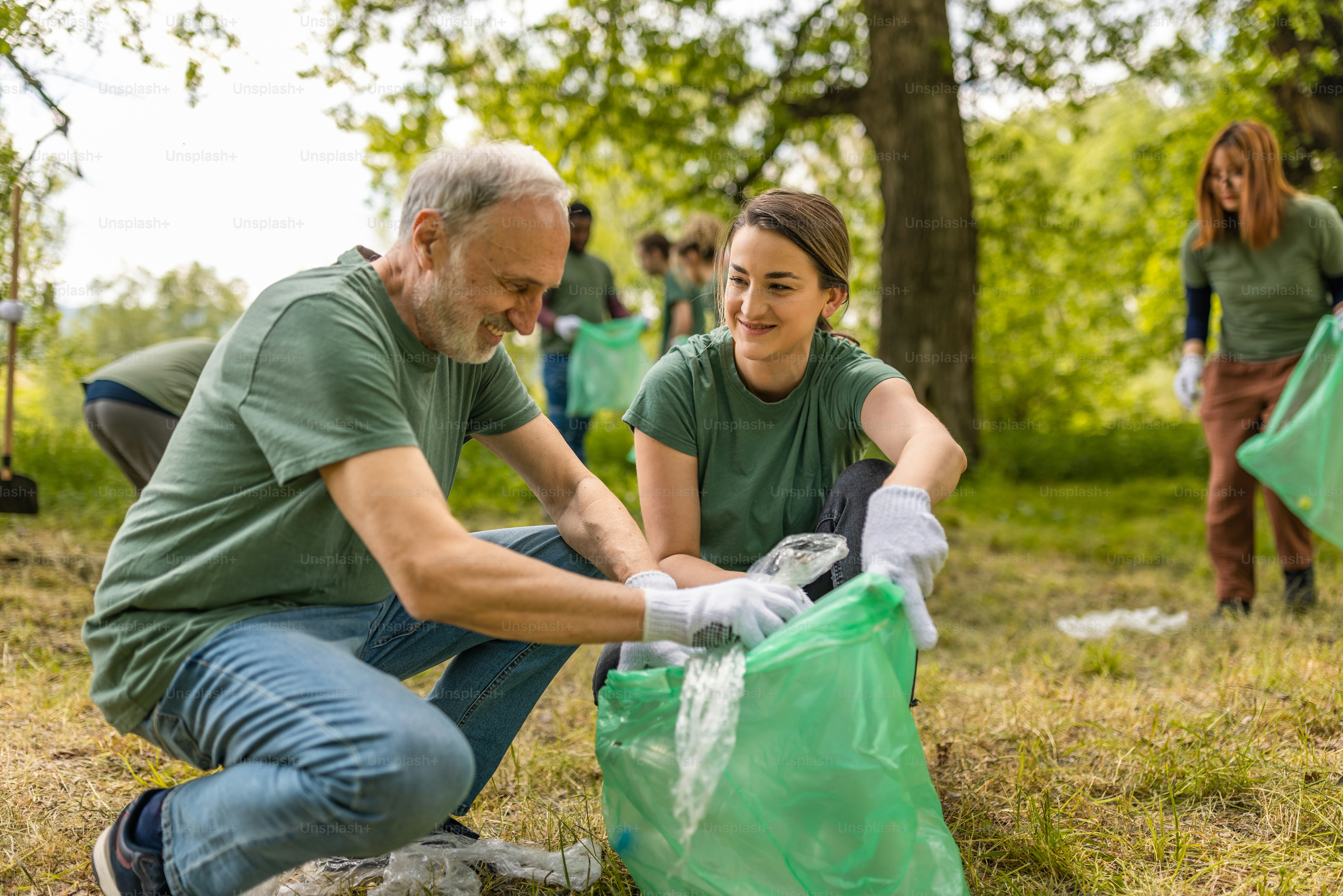 Group of environmentalist activists collecting trash in a forest together