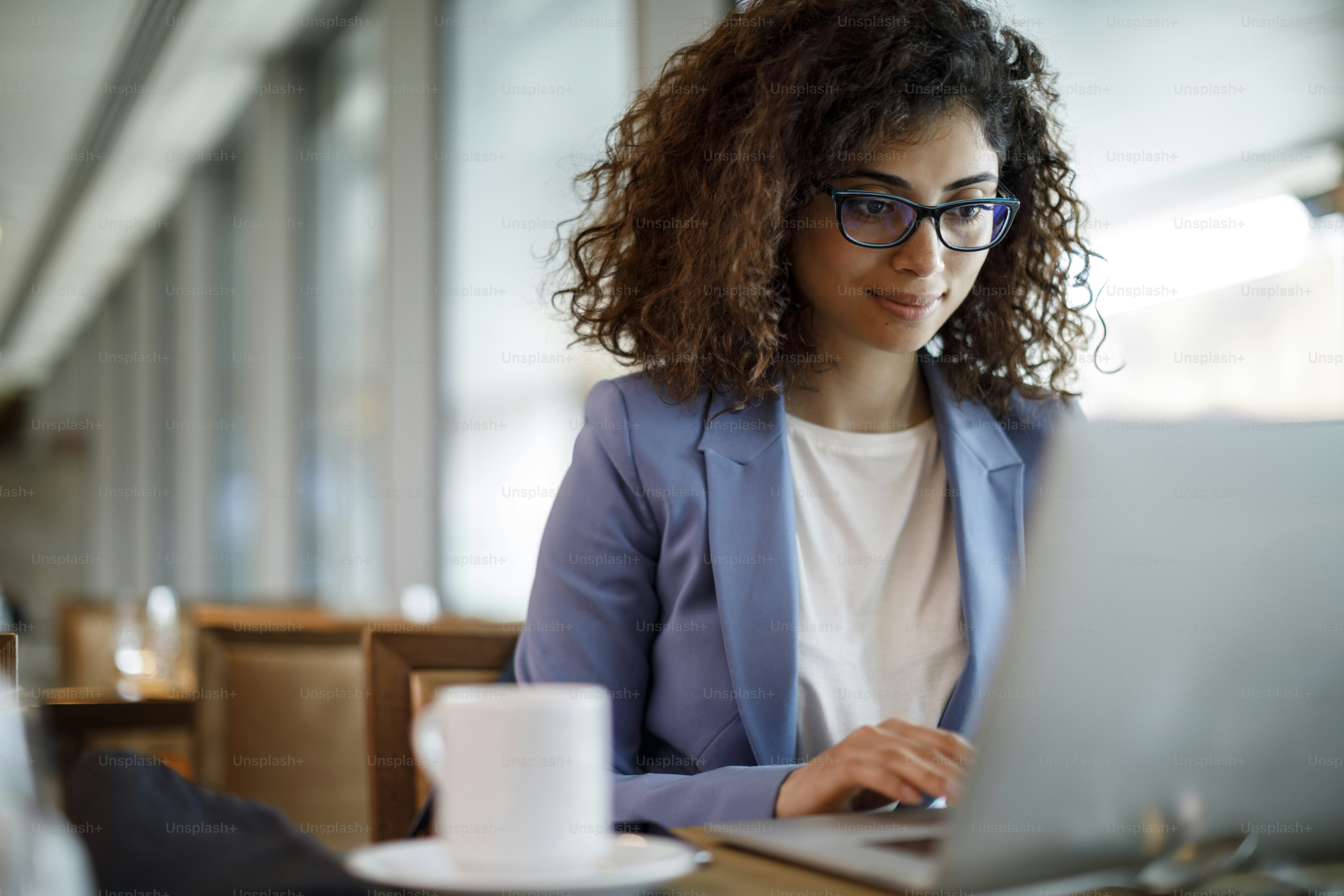 Businesswoman working on laptop at hotel cafe