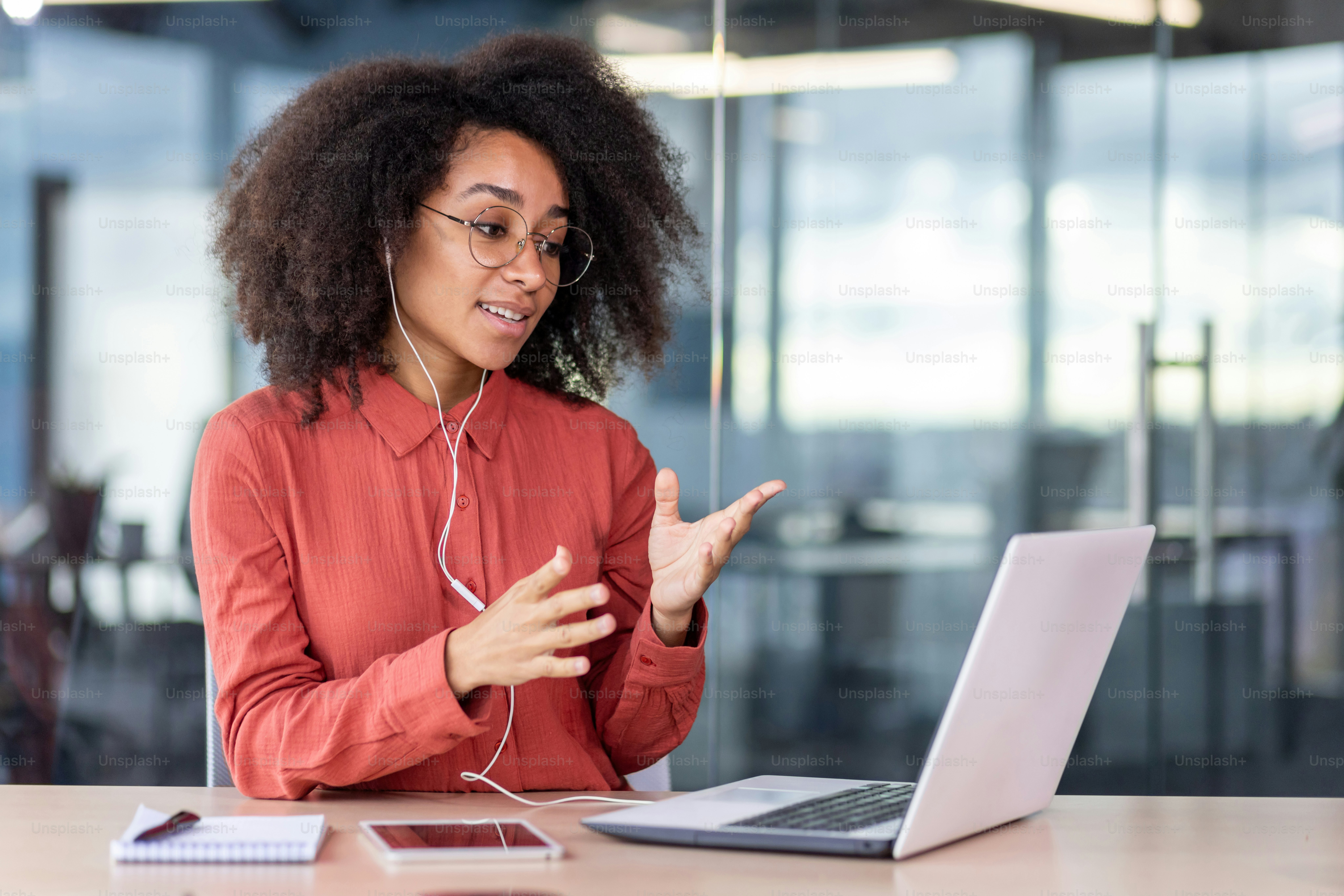 Female boss with wired headphones headset talking remotely with ...