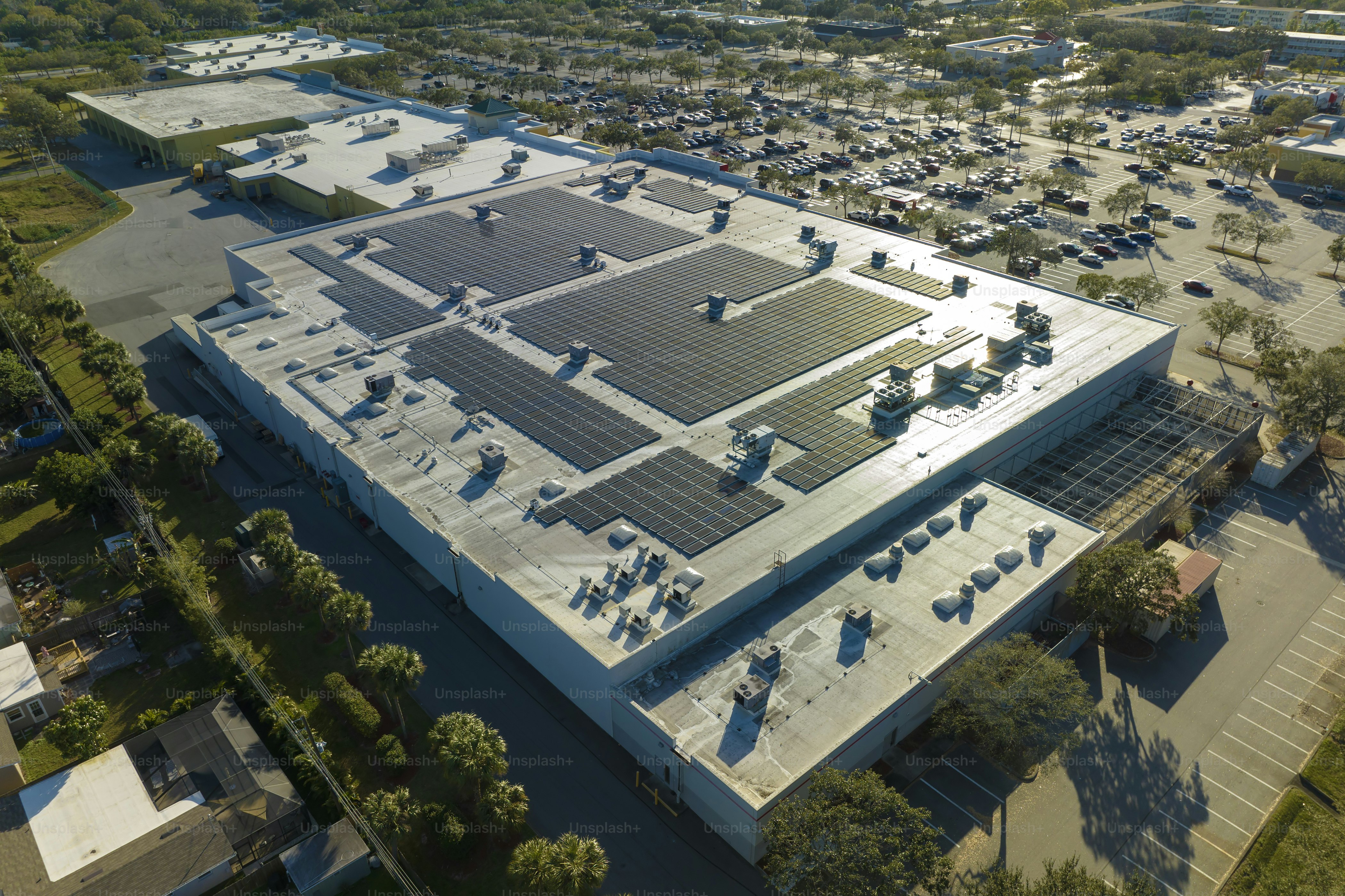 Paneles solares fotovoltaicos eléctricos instalados en la azotea de un edificio comercial para la producción de electricidad verde y ecológica. Concepto de producción de energía sostenible.