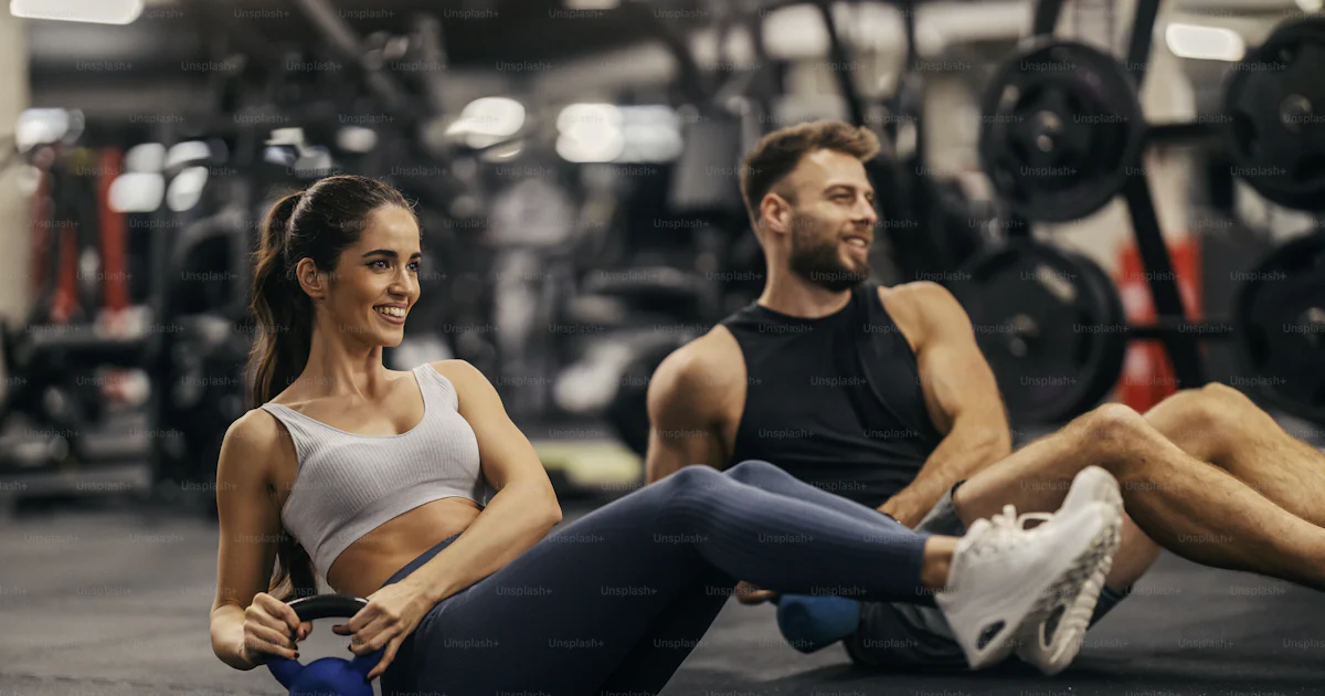 Un couple sportif en forme fait une torsion de kettlebell dans une ...