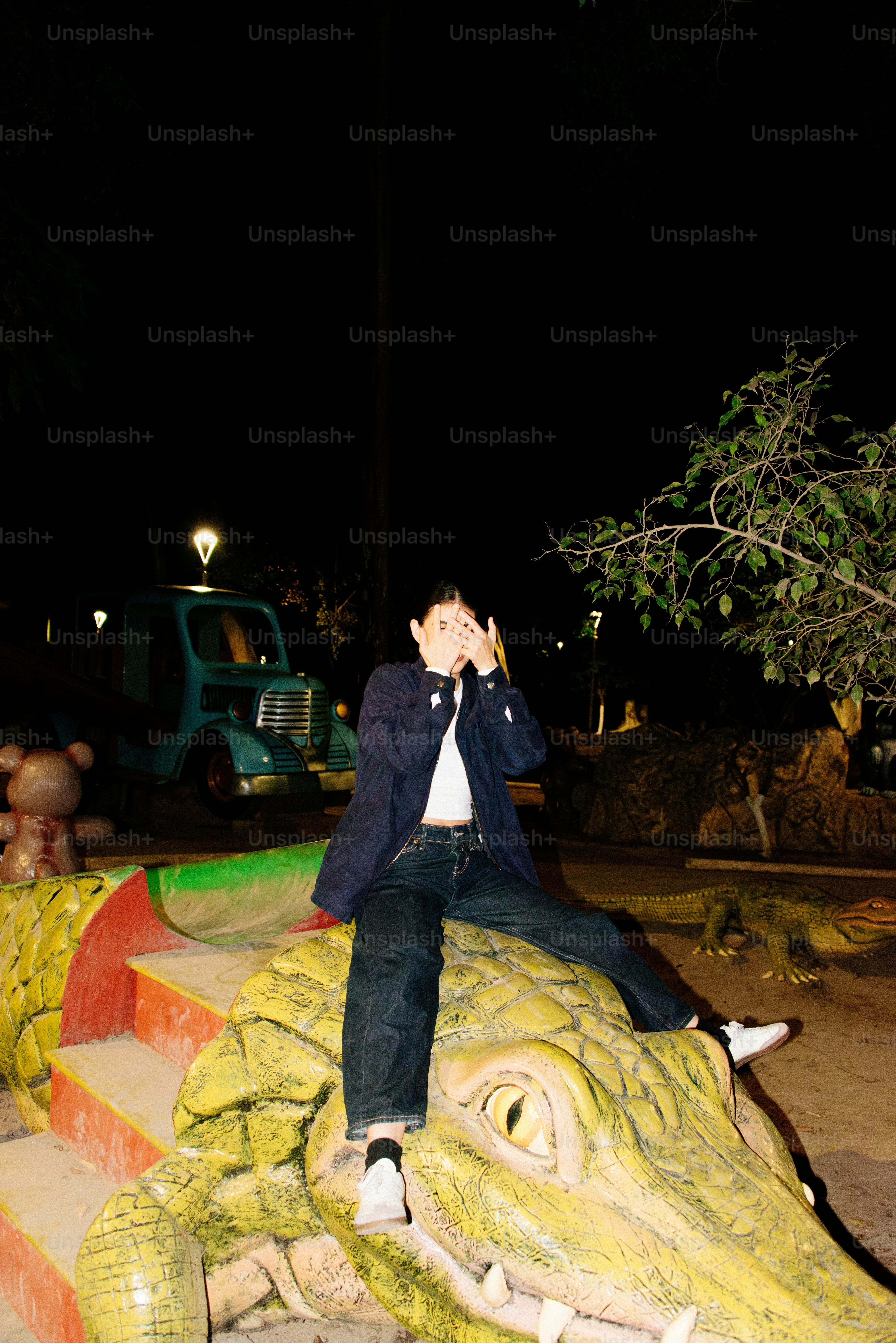 Um homem sentado em cima de um jacaré falso