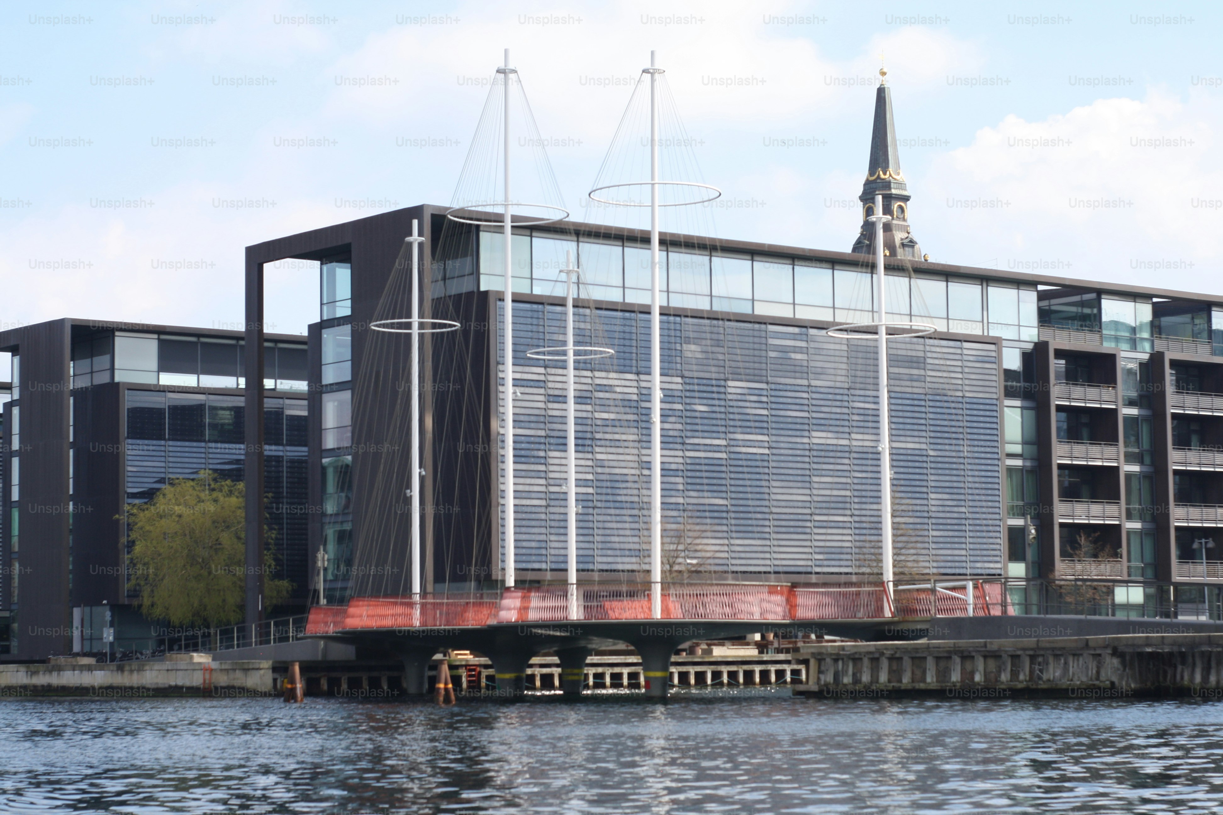 Contemporary glass building on the canal bank front wiev