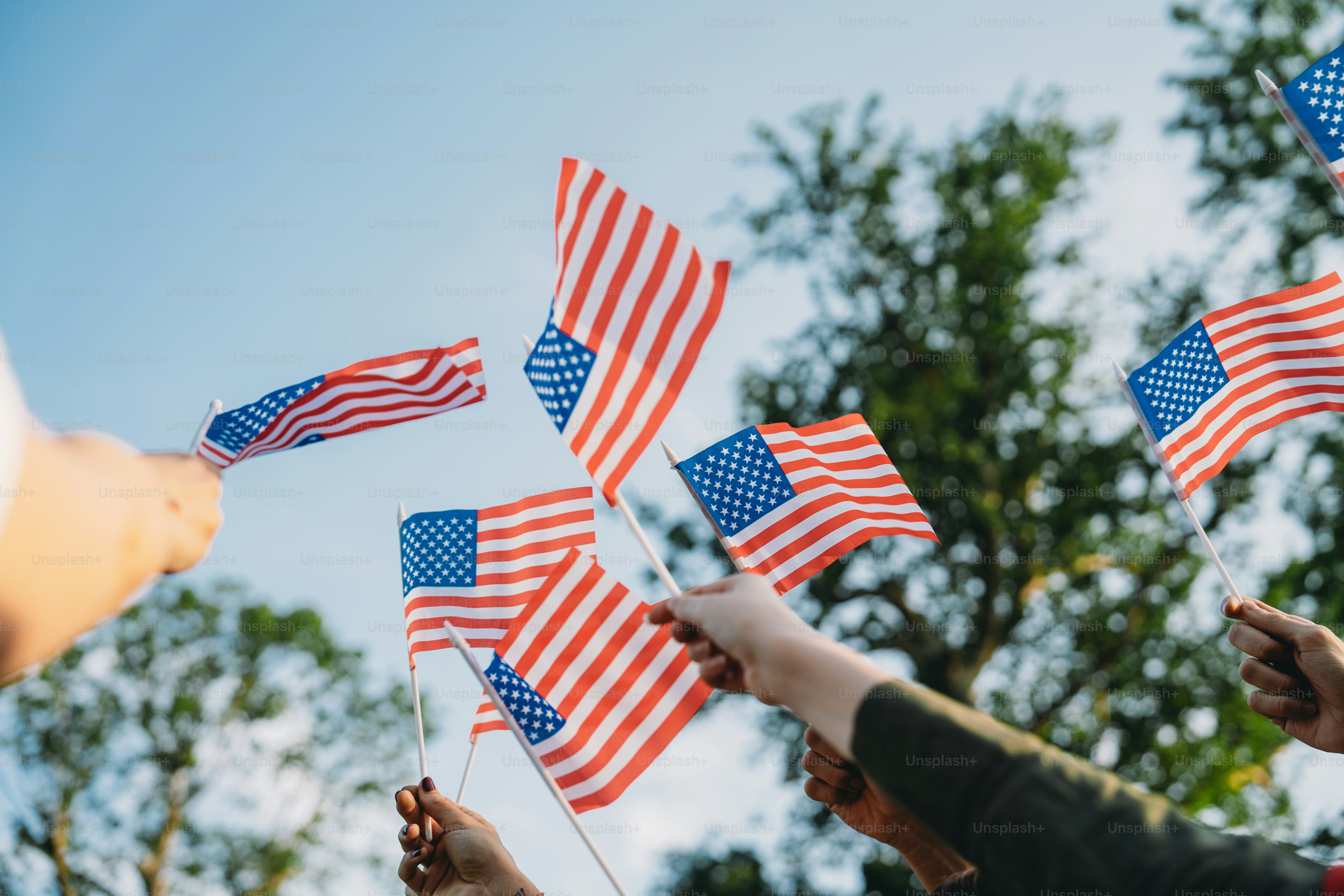 A group of people is waving small American flags at sunset. Concept for  various topics like Happy Veterans Day, Labour Day, Independence Day. photo  – Hand Image on Unsplash, image size:3000x2001