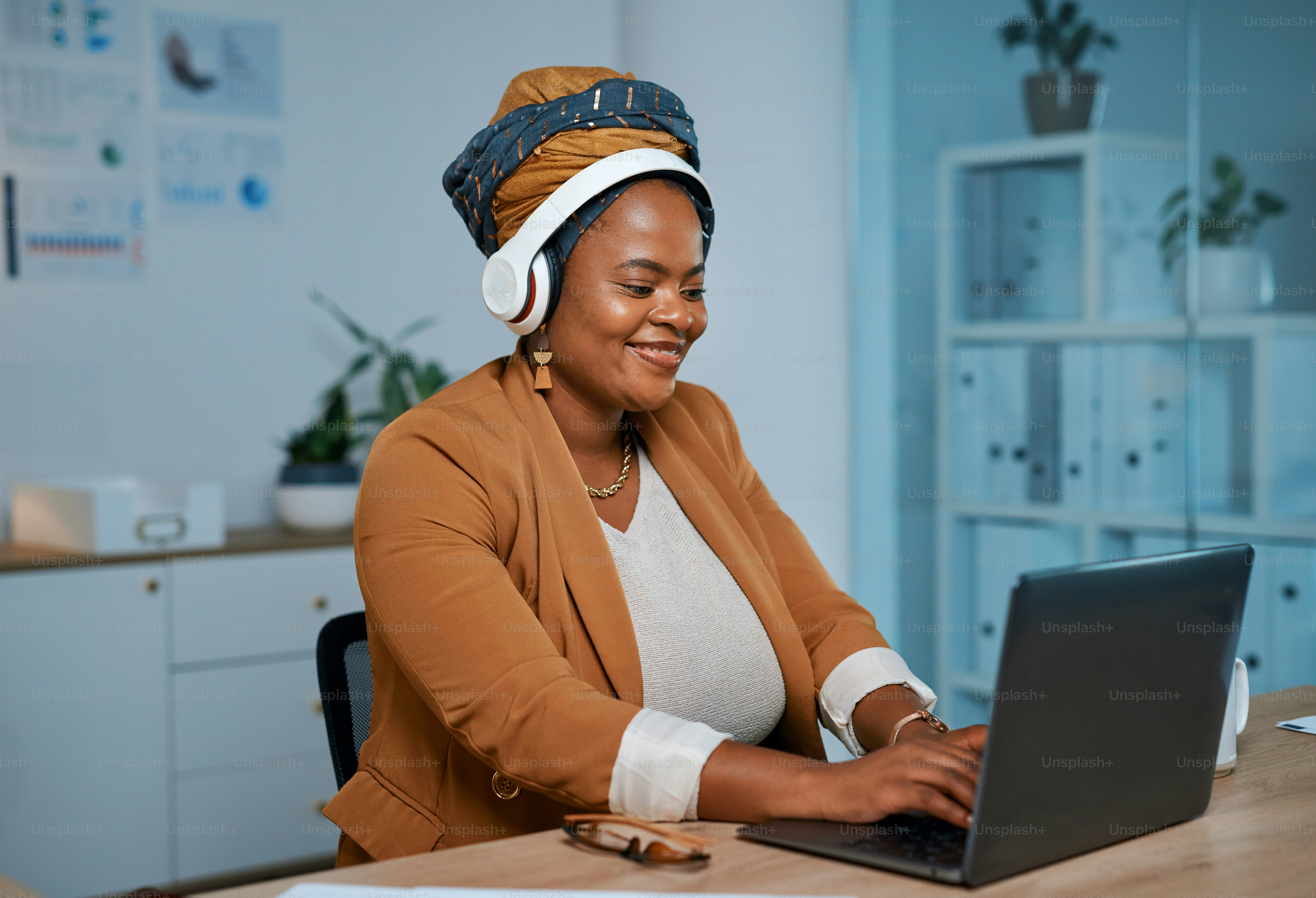 Headphones, laptop and black woman in the office typing for research on ...