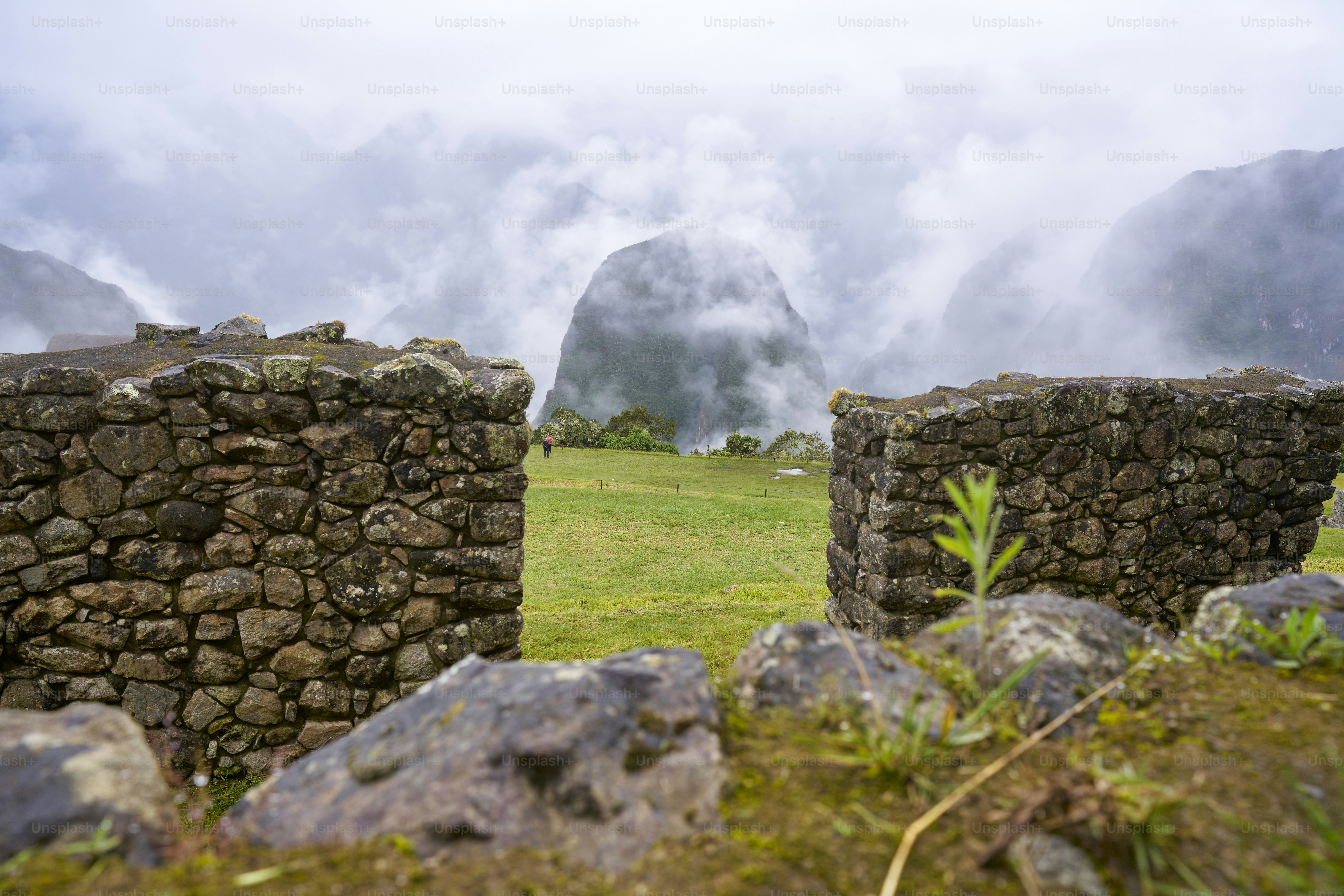 Walls in Machu Picchu focusing on Huani Picchu on a foggy day