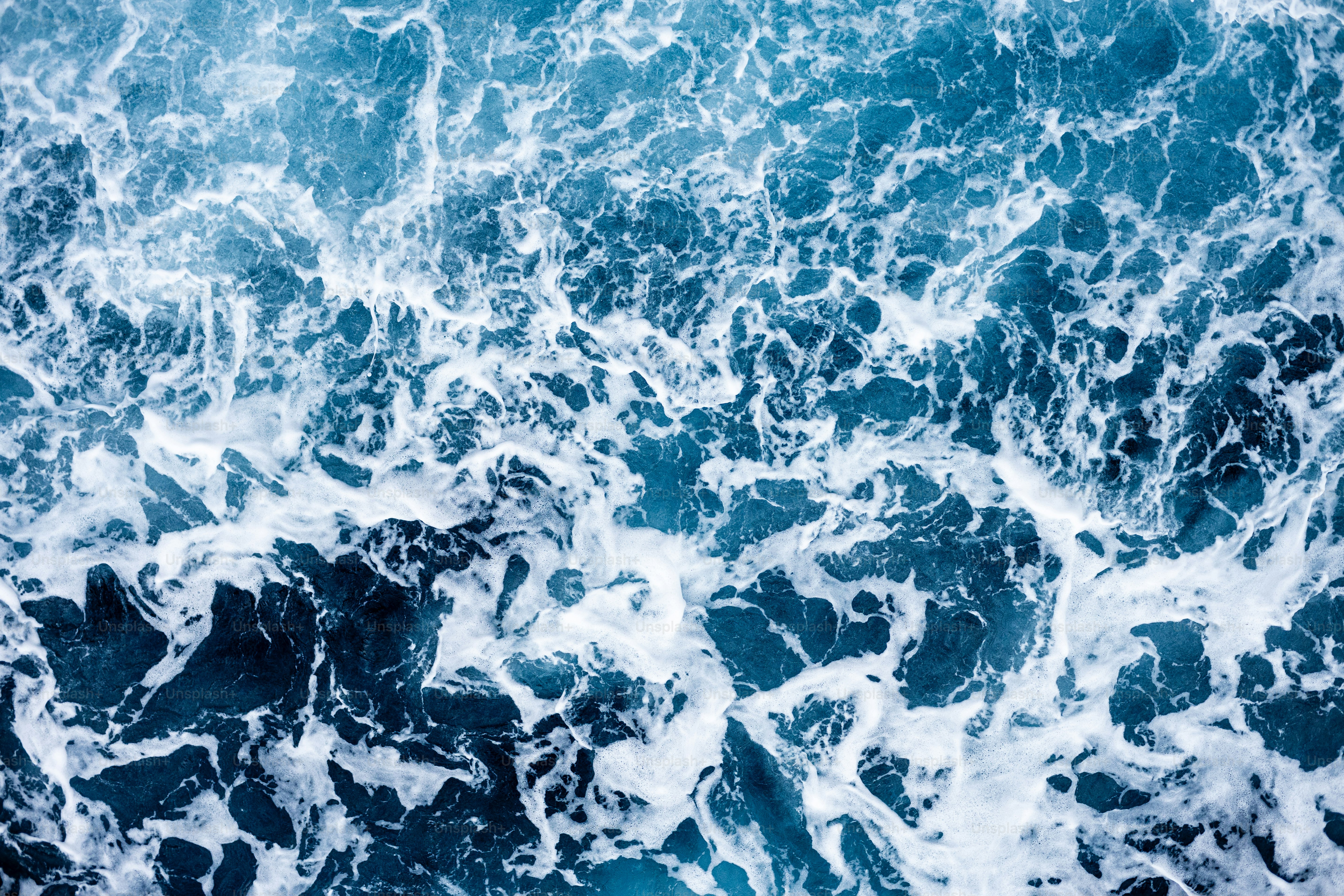 Aquamarine rough sea surface top shot, strait of messina, 2023