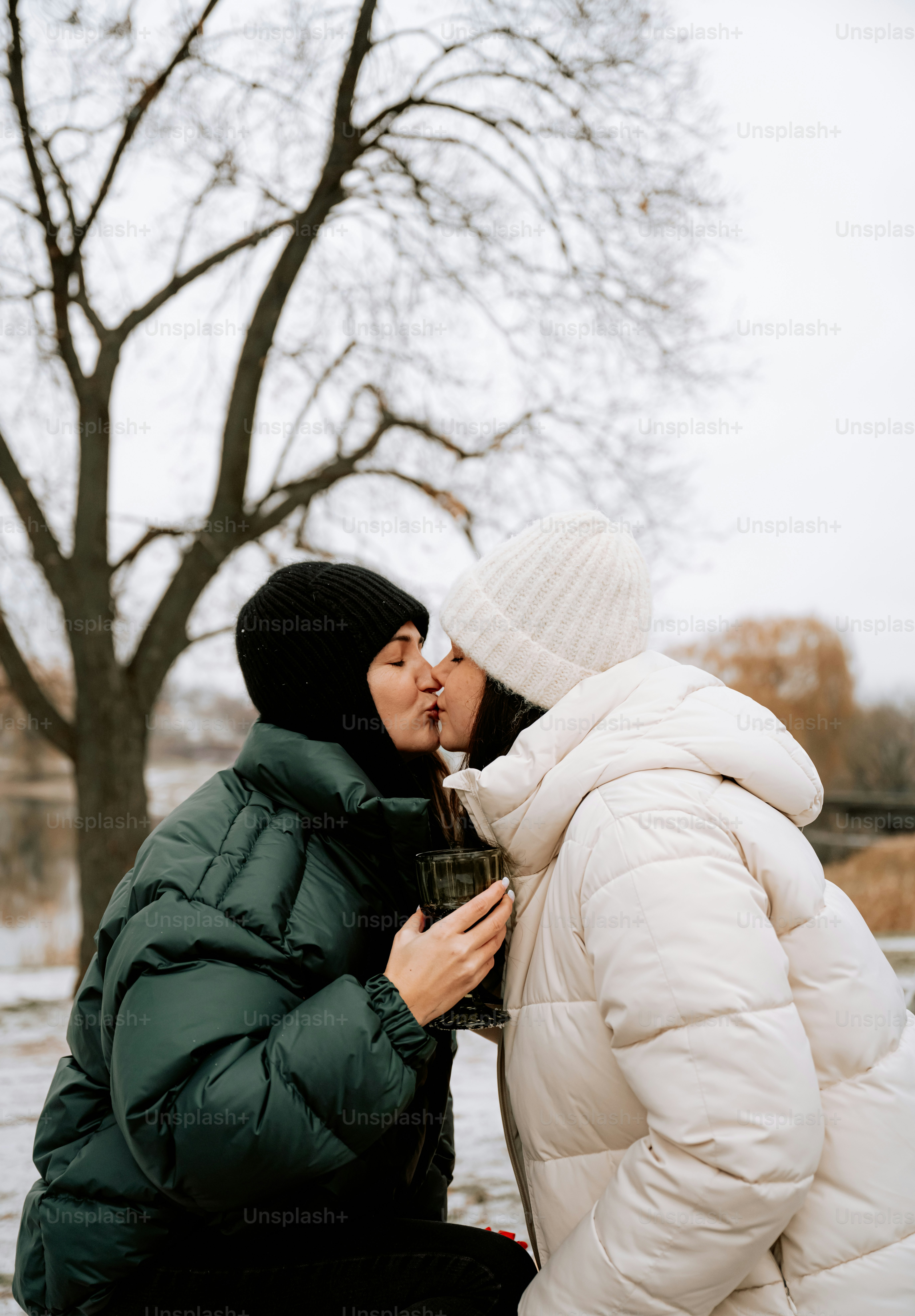 A man and a woman kissing in the snow