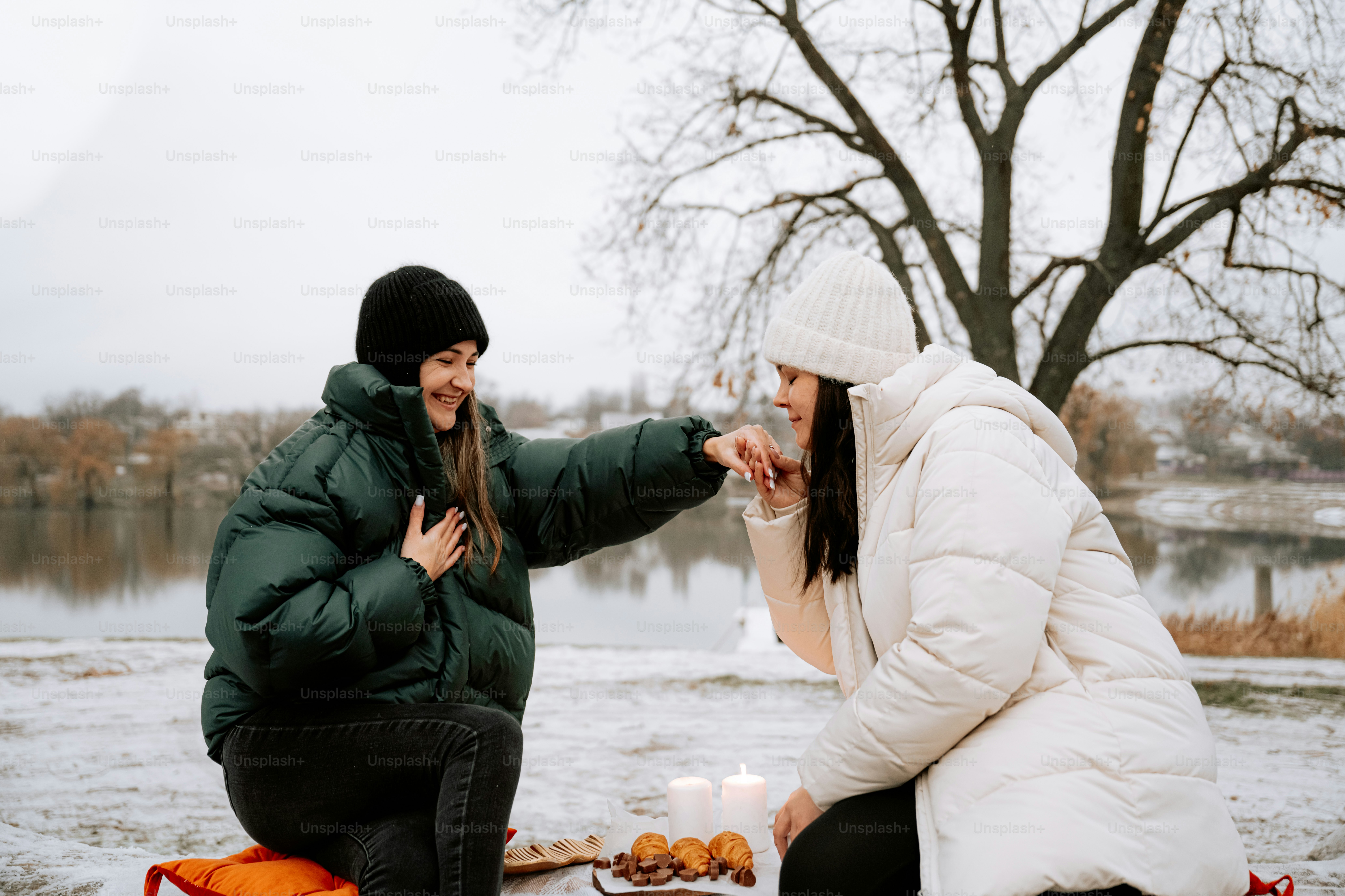 A man and a woman sitting on a bench in the snow