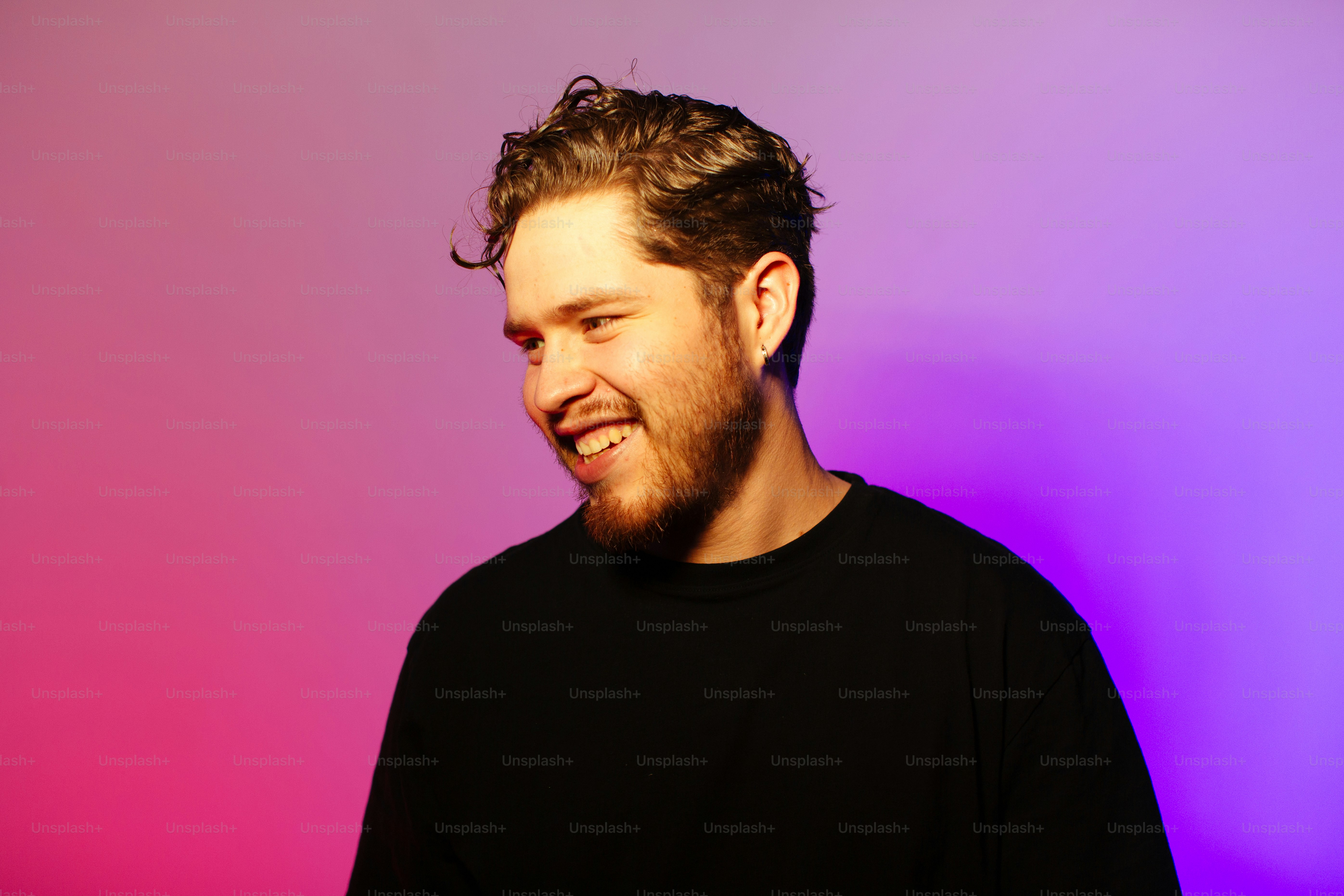 A man standing in front of a purple and pink background