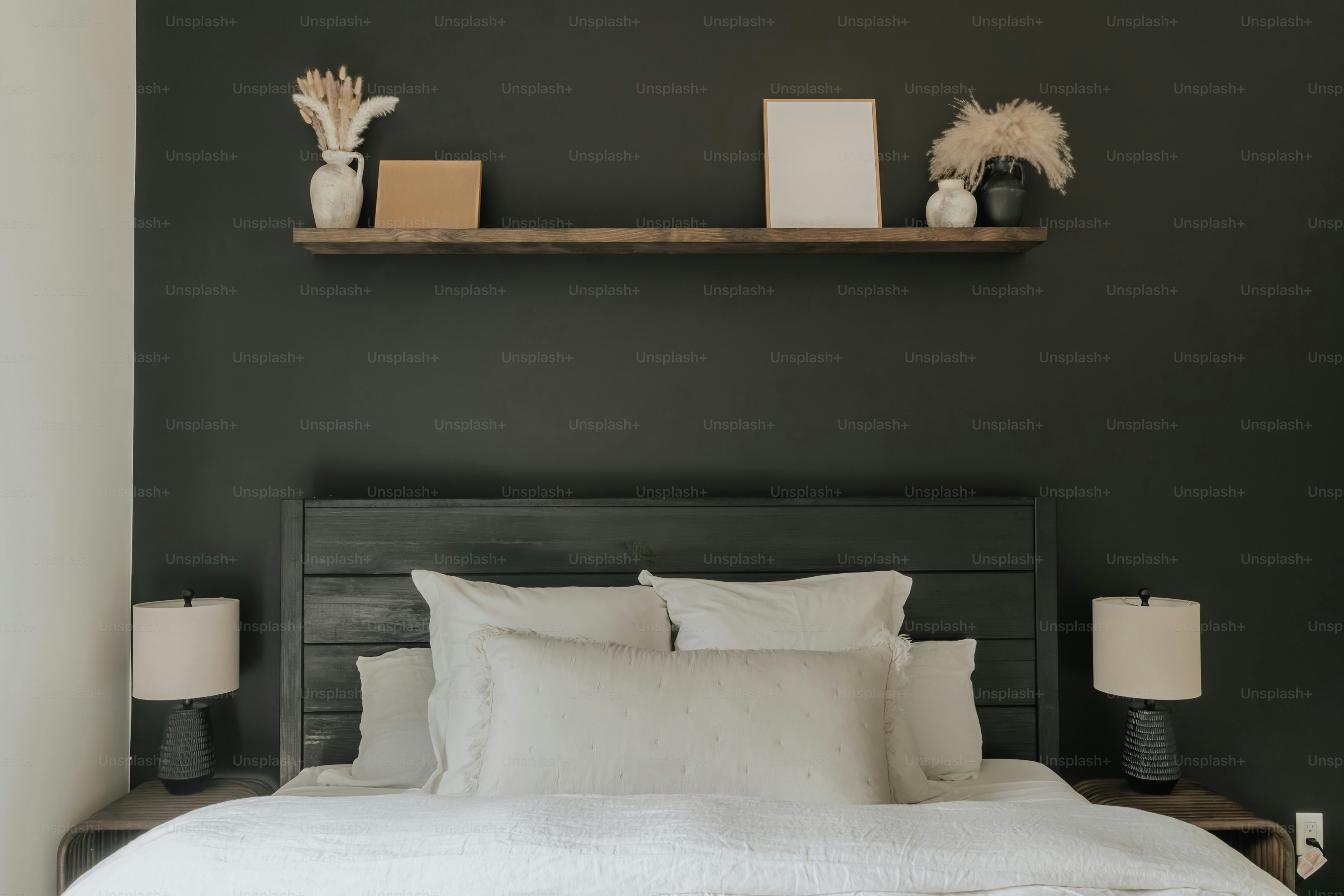 Ein Bett mit weißer Bettwäsche und Kissen in einem Schlafzimmer