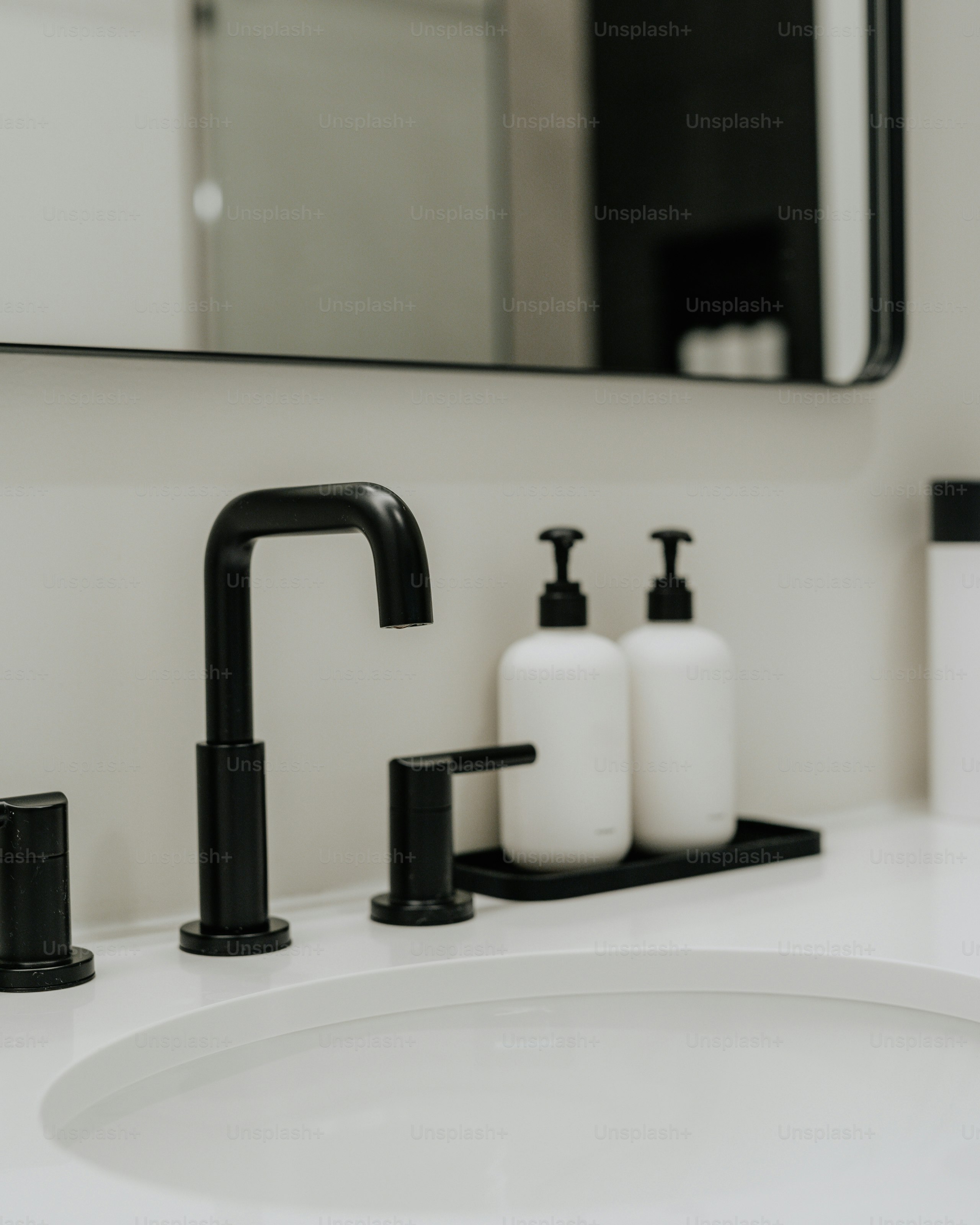 A bathroom sink with a black faucet and soap dispenser