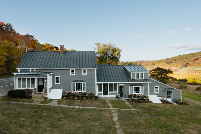 Gray farmhouse with a new standing-seam metal roof