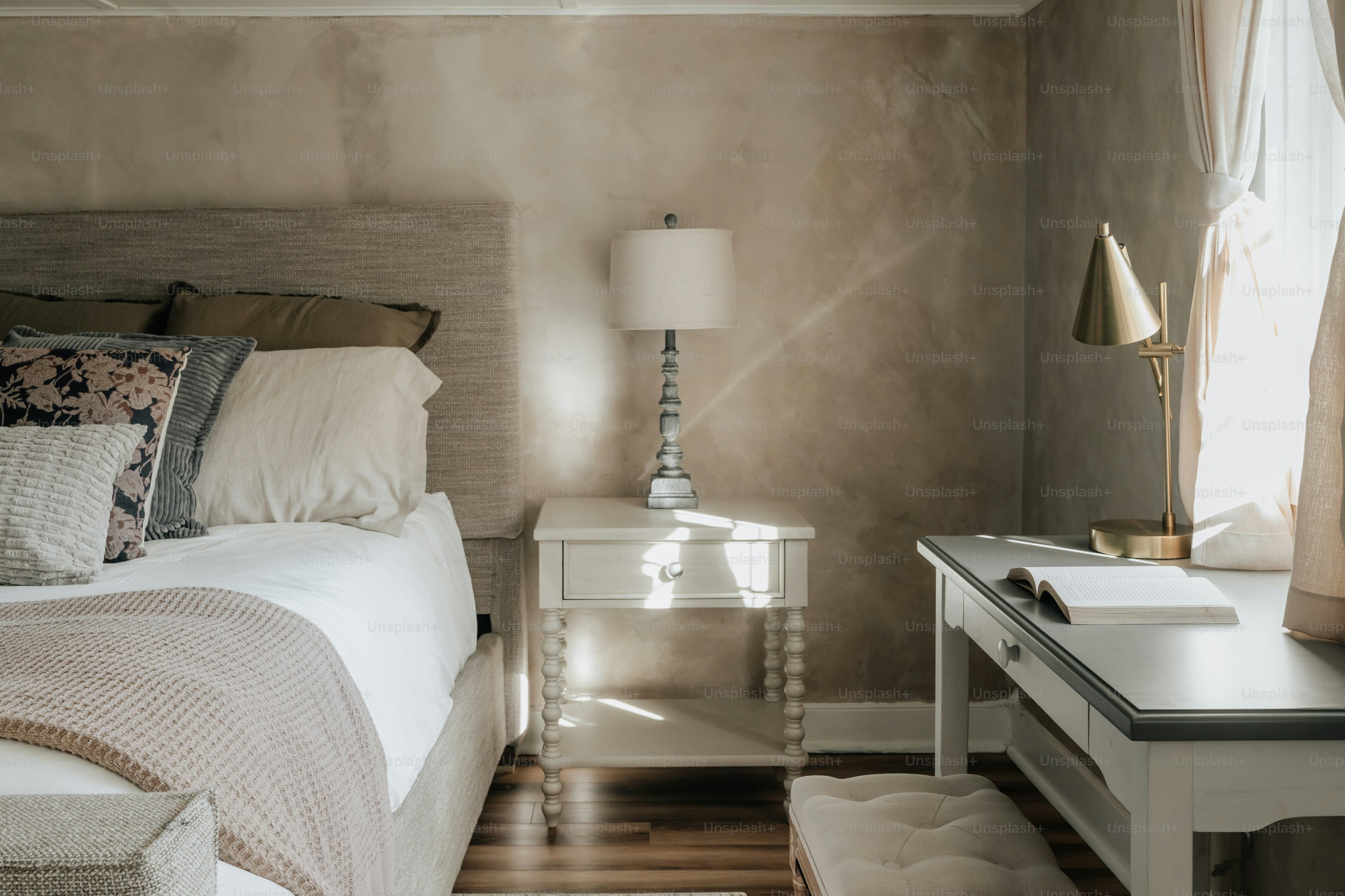 A bedroom with a bed, nightstand, and window