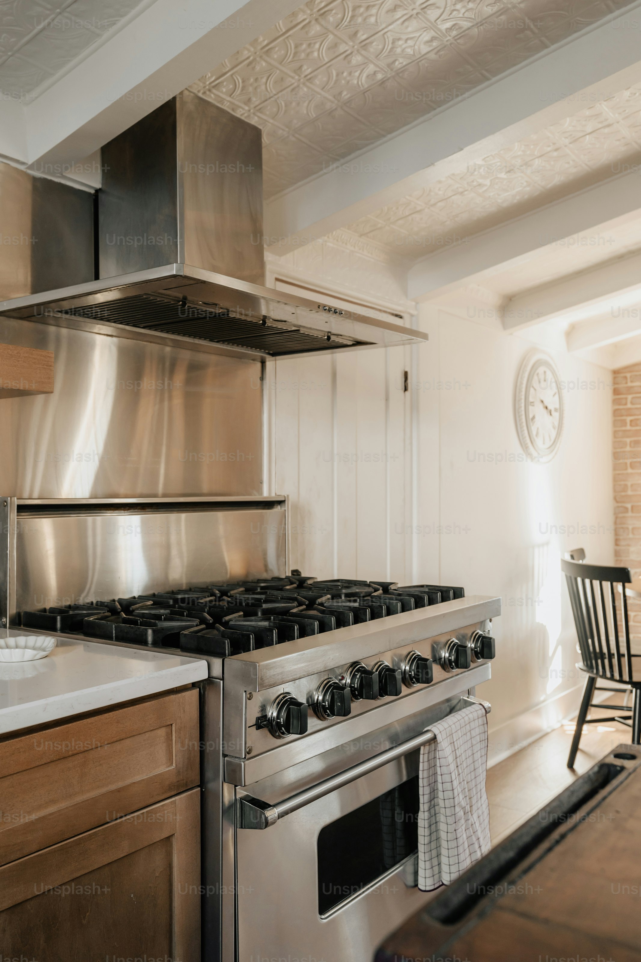 Eine Küche mit einem Herd, einem Backofen und einem Esstisch