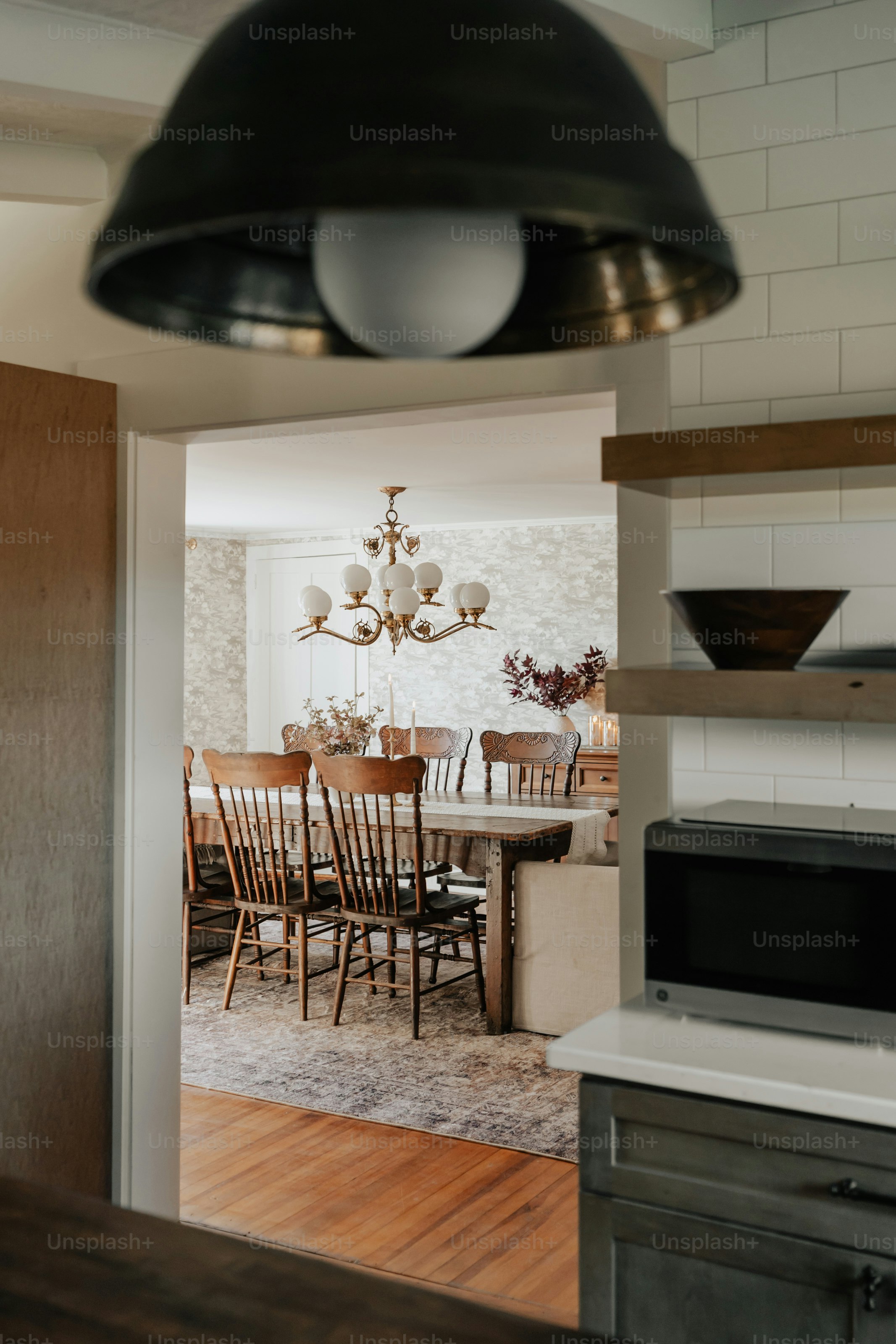 A kitchen with a microwave oven and a dining room table