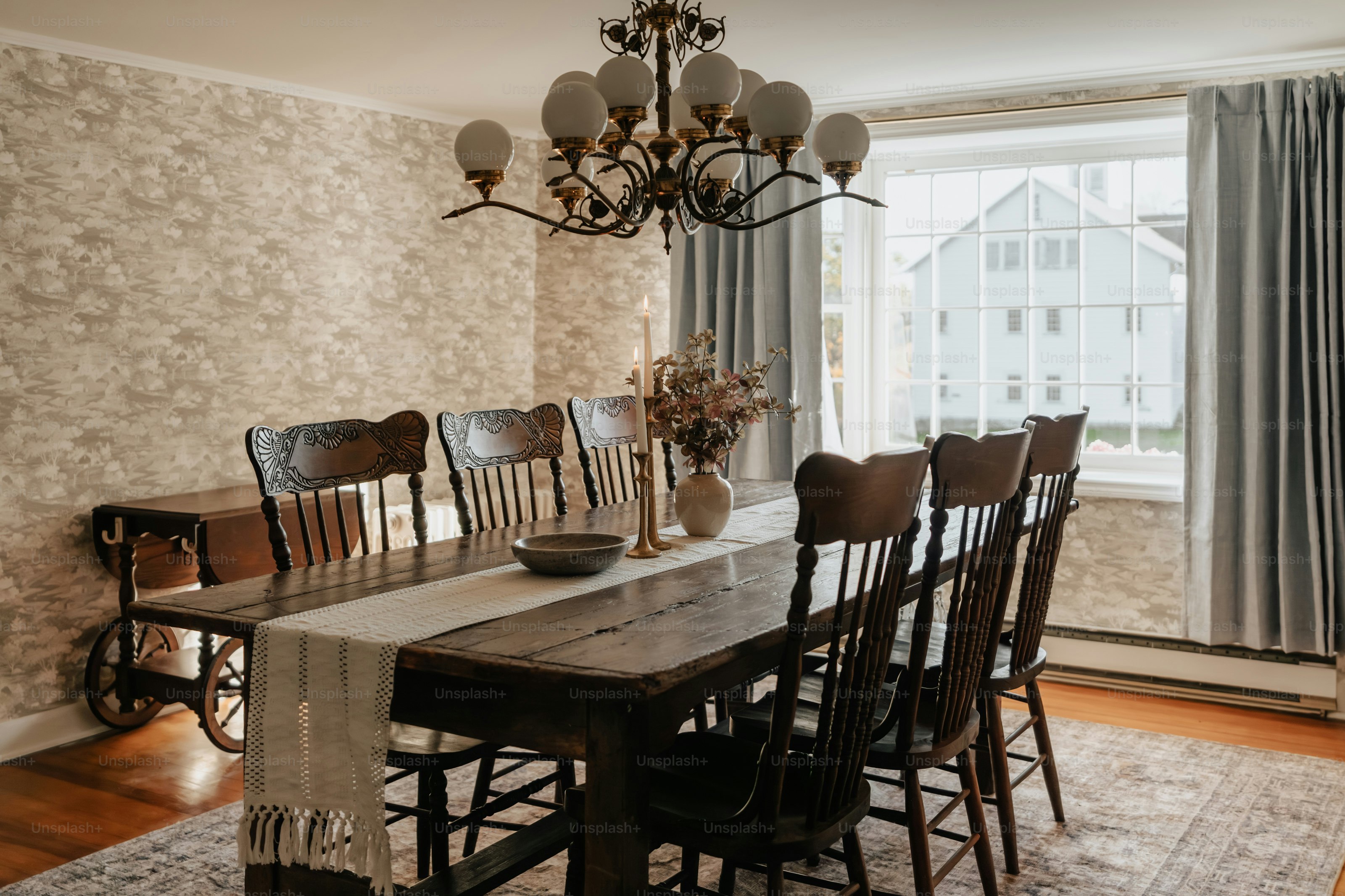 A dining room table and chairs with a chandelier