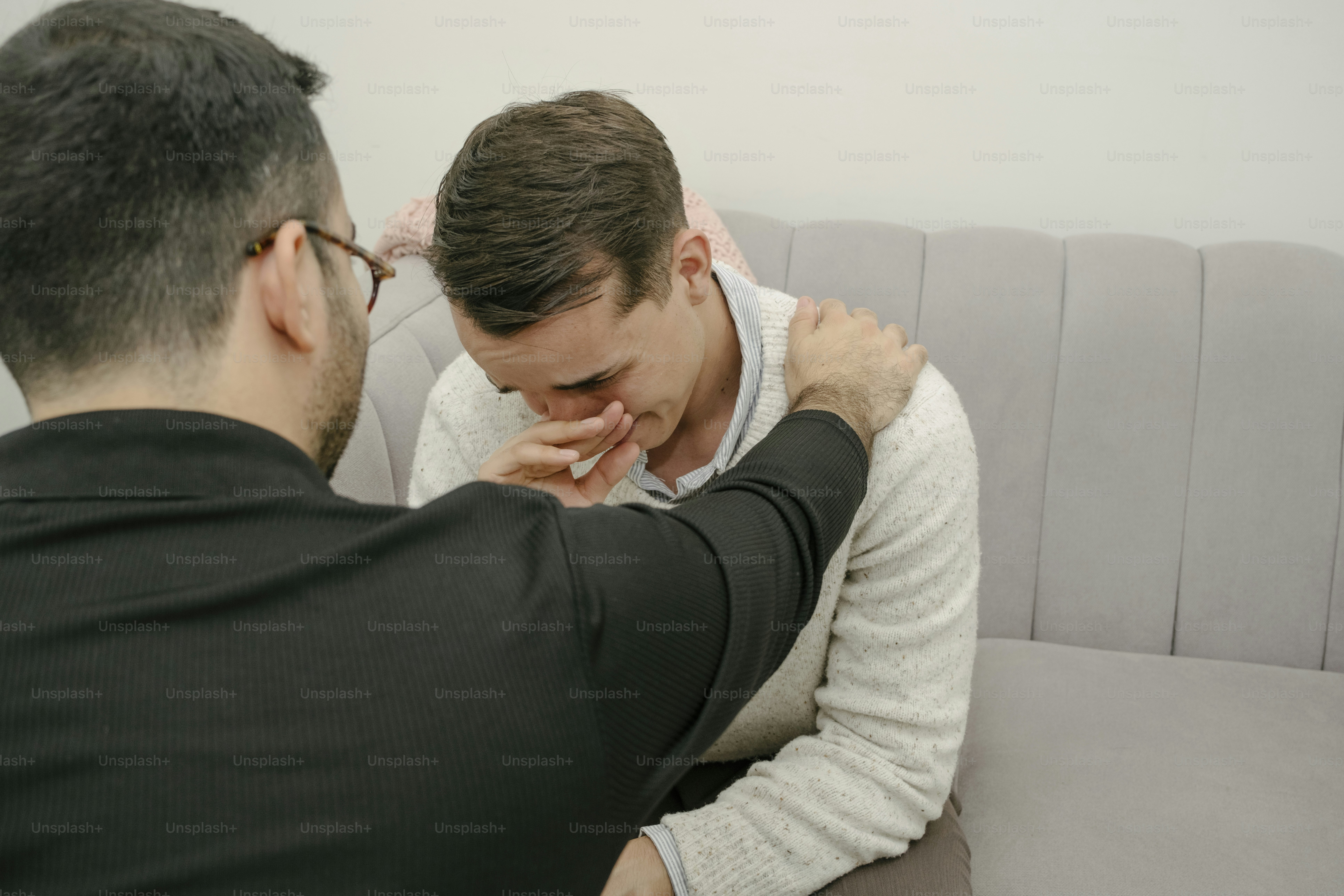 A couple of men sitting on top of a couch